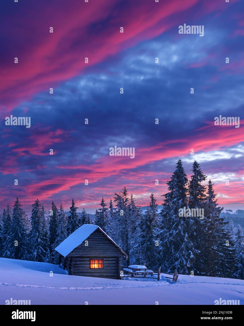 Fantastische Landschaft, die durch Sonnenlicht Leuchten. Dramatische winterliche Szene mit verschneiten Haus. Karpaten, Ukraine, Europa. Stockfoto