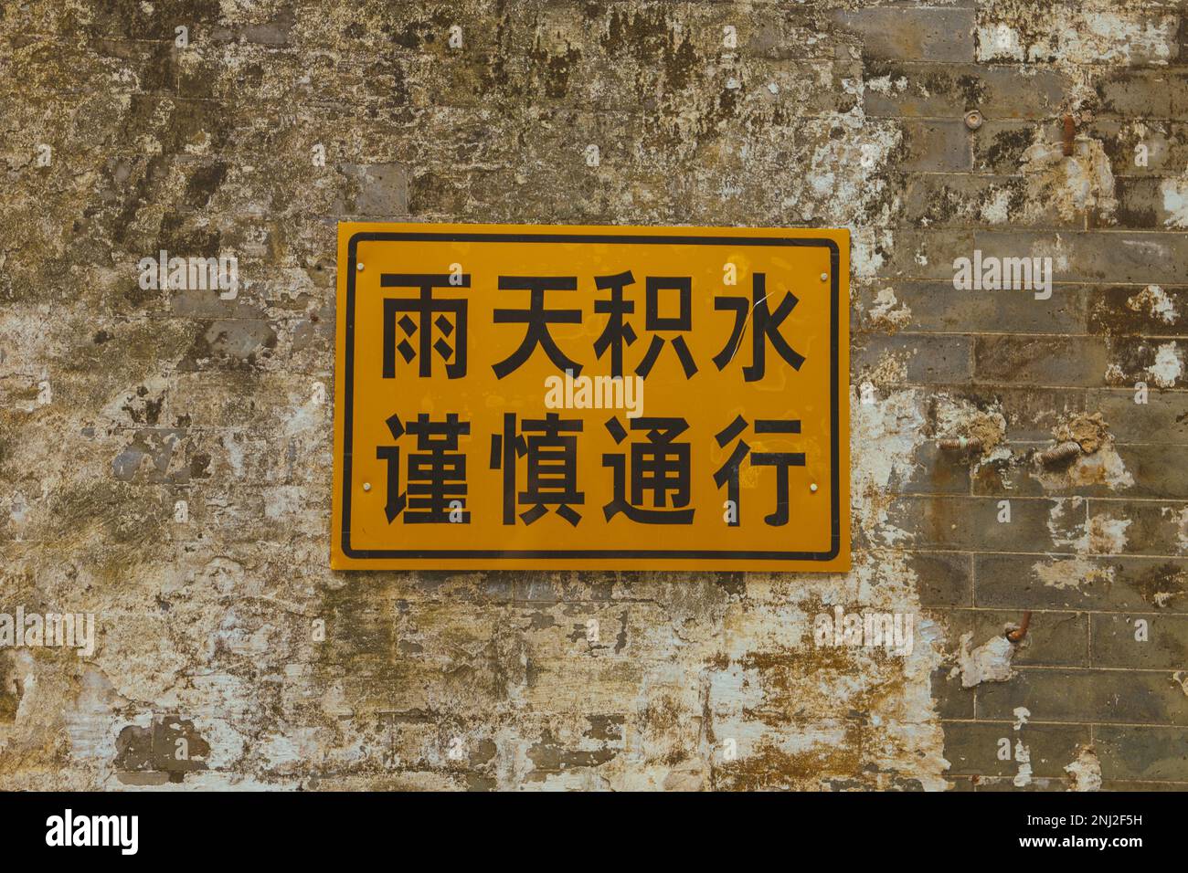 Chinesisches Warnschild (Übersetzung: Bei Regen, Wasserprotokollierung, vorsichtig vorgehen) Stockfoto