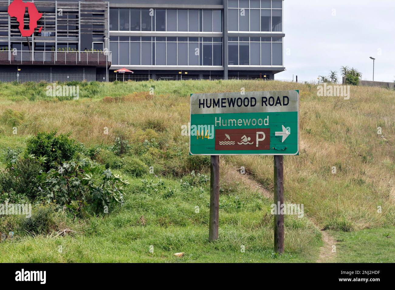 Humewood Road-Schild, Gqeberha (Port Elizabeth), Südafrika, mit der Zentrale von Coca-Cola Beverages Africa (CCBA) im Hintergrund. Stockfoto