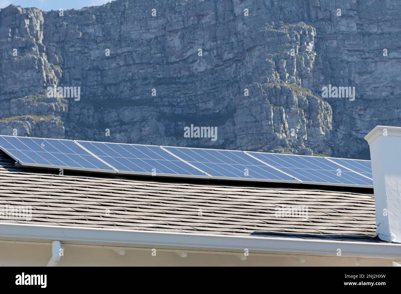 Team, das hybride netzgebundene elektrische Installation von Solarmodulen, Wechselrichtern und Reservebatterien installiert, um Lastabwurf in Südafrika zu bekämpfen. Stockfoto