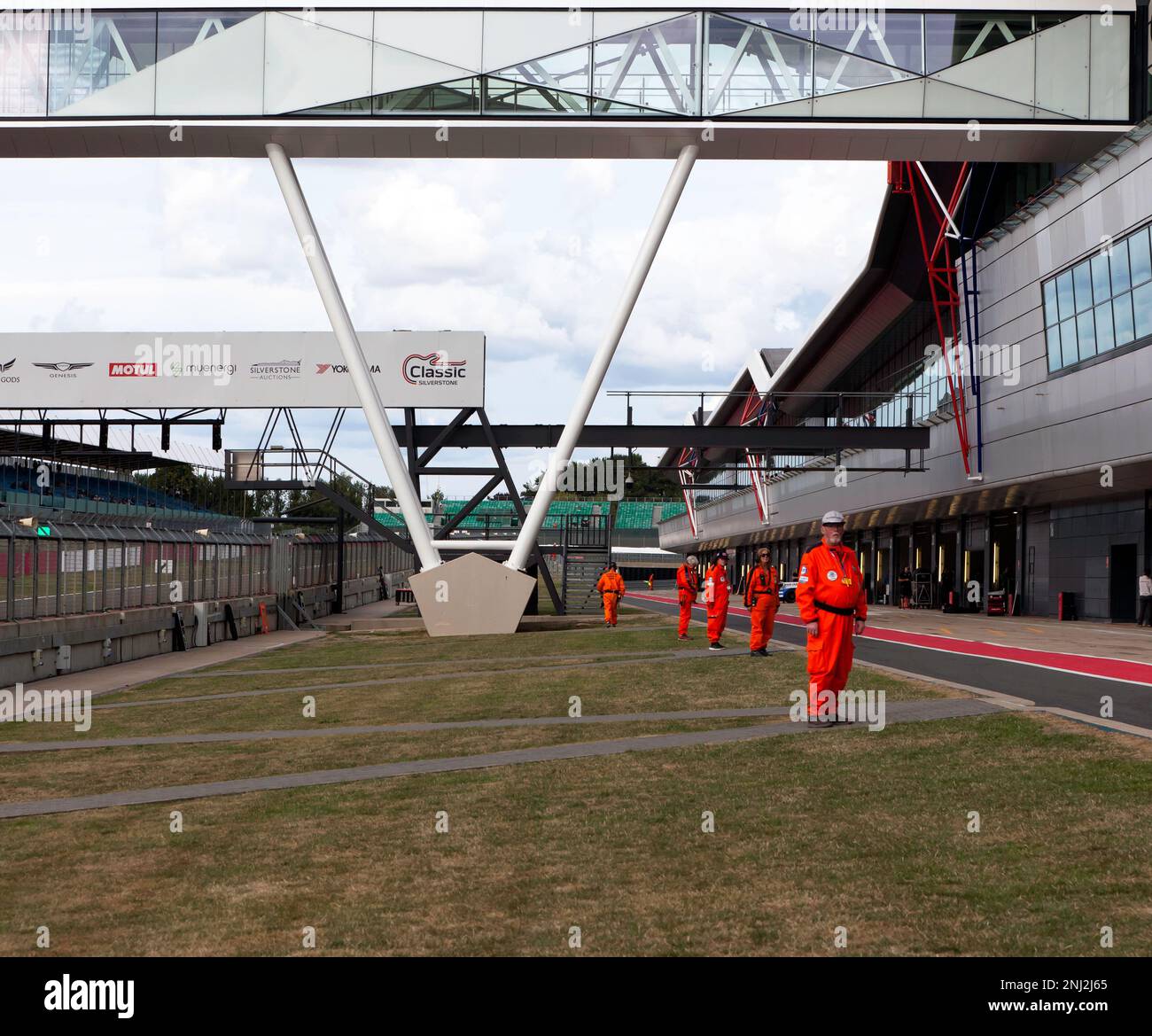 Die Silverstone Marshalls stehen bereit, um den Rollstart der Masters GT4 Classic Silverstone Challenge unter dem Sicherheitswagen zu steuern Stockfoto