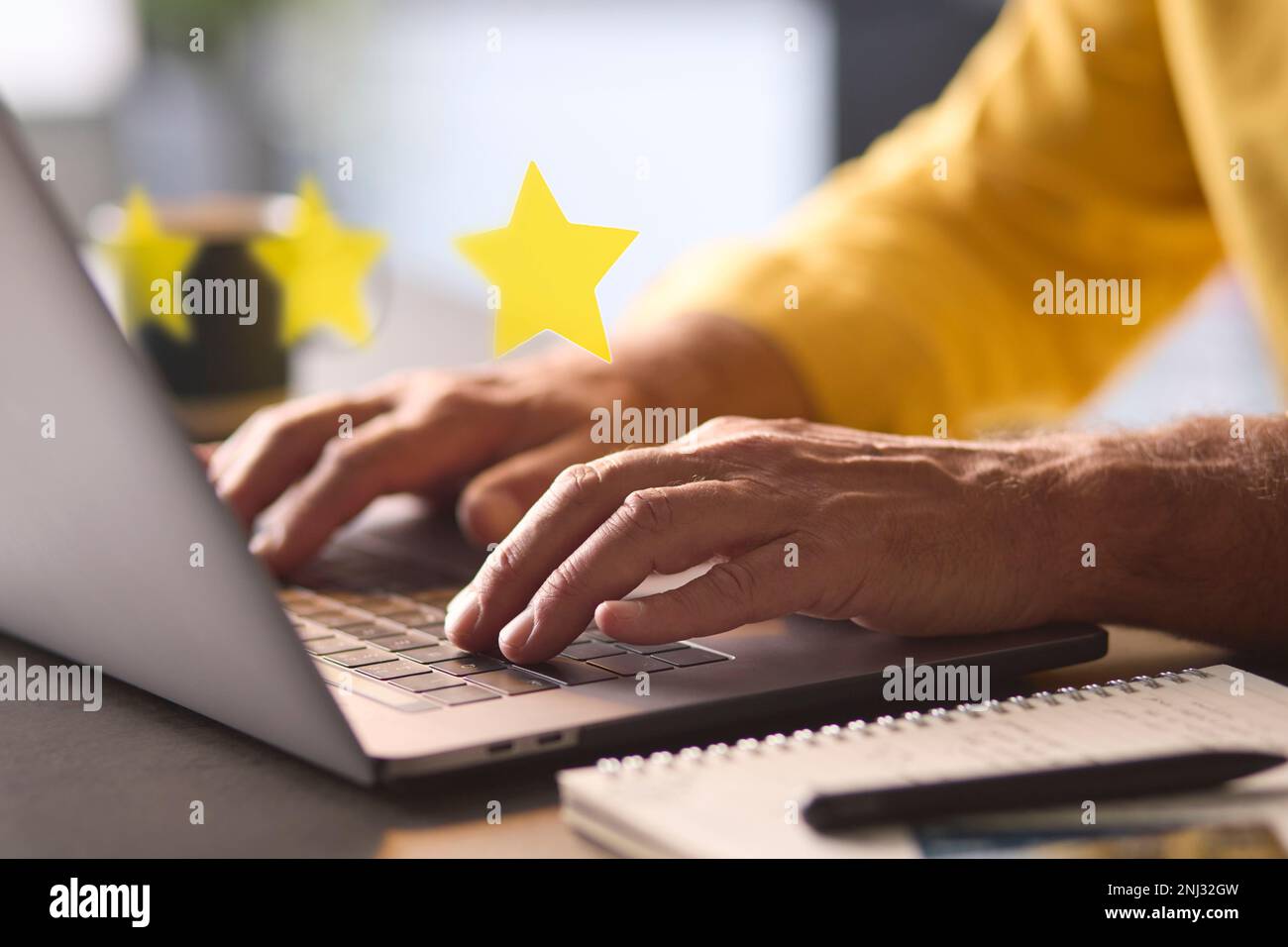 Mann, Der Ein Notebook Mit Grafiküberlagerung Verwendet, Um Eine Positive 5-Sterne-Online-Bewertung Zu Hinterlassen Stockfoto