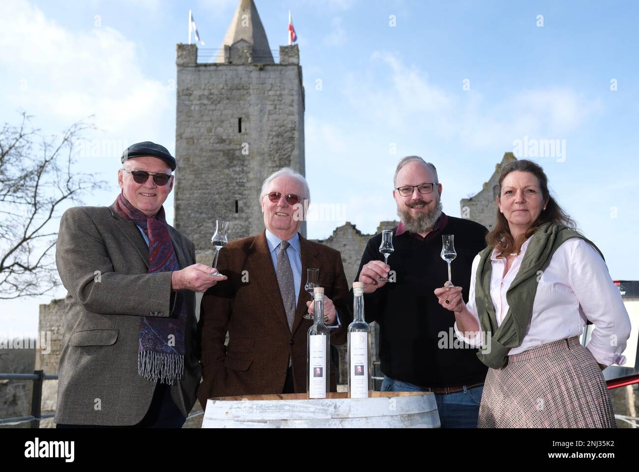 Naumburg, Deutschland. 22. Februar 2023. Georg Schenk (l-r), Distiller mit Sitz in Görlitz, Franz-Friedrich Prinz von Preußen, Thiemo von Creytz, Restaurateur, und Christine Prinzessin von Preußen, Restaurateur, stehen mit Obstbranntwein vor Schloss Rudelsburg. Der Anlass ist die Präsentation der Kaiser-Wilhelm-Apfelbrandy-Ausgabe. Das Haus Hohenzollern unterstützt das Projekt und stellte ein Porträt von Kaiser Wilhelm, dem ersten für das Label, bereit. Kredit: Sebastian Willnow/dpa/Alamy Live News Stockfoto