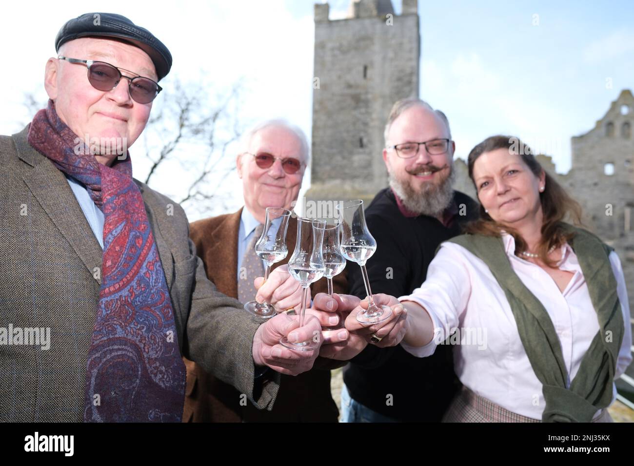 Naumburg, Deutschland. 22. Februar 2023. Georg Schenk (l-r), Distiller mit Sitz in Görlitz, Franz-Friedrich Prinz von Preußen, Thiemo von Creytz, Restaurateur, und Christine Prinzessin von Preußen, Restaurateur, stehen mit Obstbranntwein vor Schloss Rudelsburg. Der Anlass ist die Präsentation der Kaiser-Wilhelm-Apfelbrandy-Ausgabe. Das Haus Hohenzollern unterstützt das Projekt und stellte ein Porträt von Kaiser Wilhelm, dem ersten für das Label, bereit. Kredit: Sebastian Willnow/dpa/Alamy Live News Stockfoto
