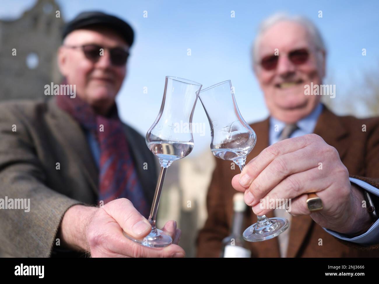 Naumburg, Deutschland. 22. Februar 2023. Georg Schenk (l), ein Brenner mit Sitz in Görlitz, und Franz-Friedrich Prinz von Preußen stehen mit Obstbranntwein vor dem Schloss Rudelsburg. Der Anlass ist die Präsentation der Kaiser-Wilhelm-Apfelbrandy-Ausgabe. Das Haus Hohenzollern unterstützt das Projekt und stellte ein Porträt von Kaiser Wilhelm, dem ersten für das Label, bereit. Kredit: Sebastian Willnow/dpa/Alamy Live News Stockfoto