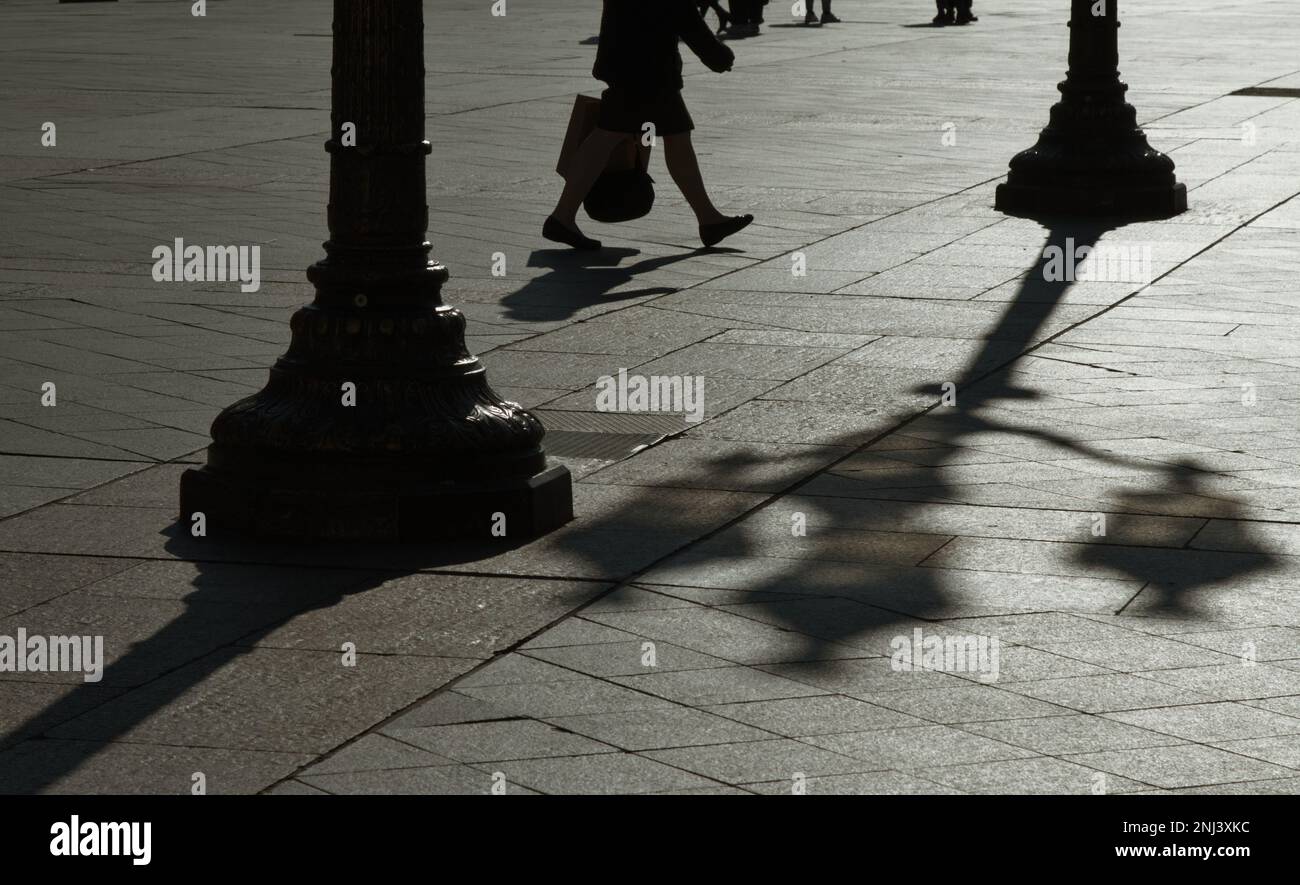 Person, die durch den Innenhof des Hotels De Ville mit Silhouetten der Lampen im französischen Frühling Paris geht Stockfoto