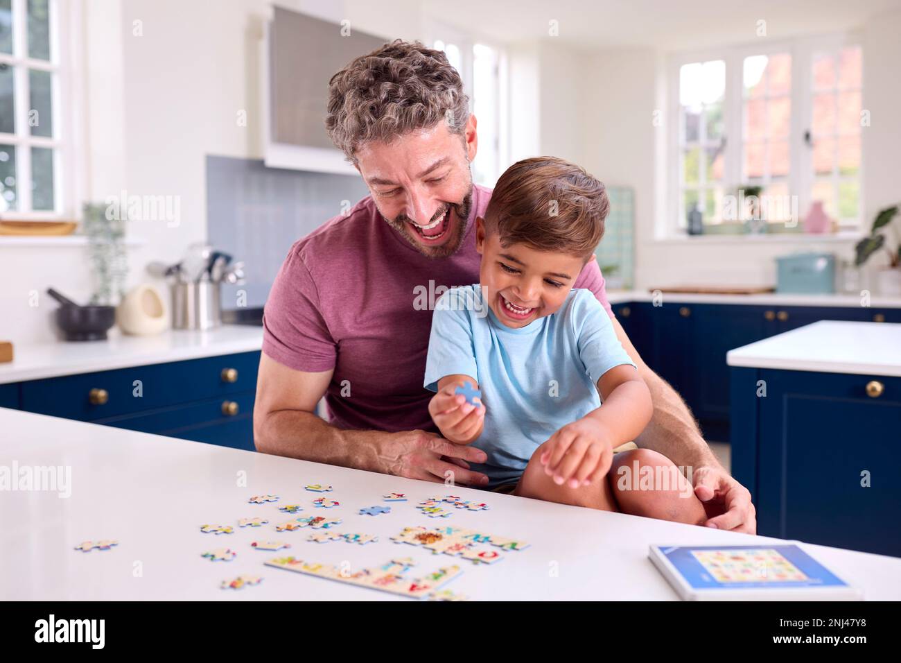 Reifer Vater Zu Hause In Der Küche, Mit Sohn, Der Zusammen Puzzle Spielt Stockfoto