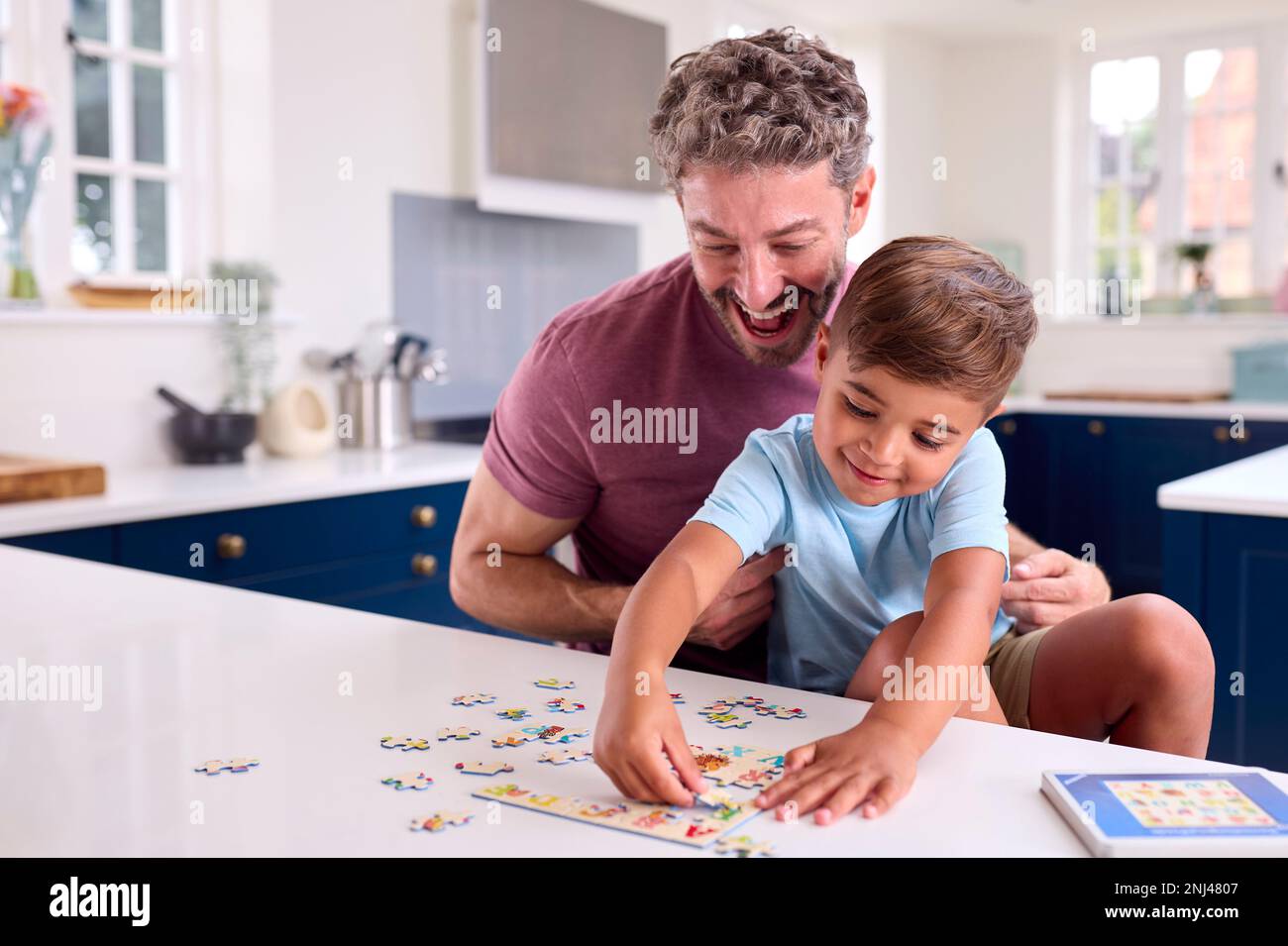 Reifer Vater Zu Hause In Der Küche, Mit Sohn, Der Zusammen Puzzle Spielt Stockfoto