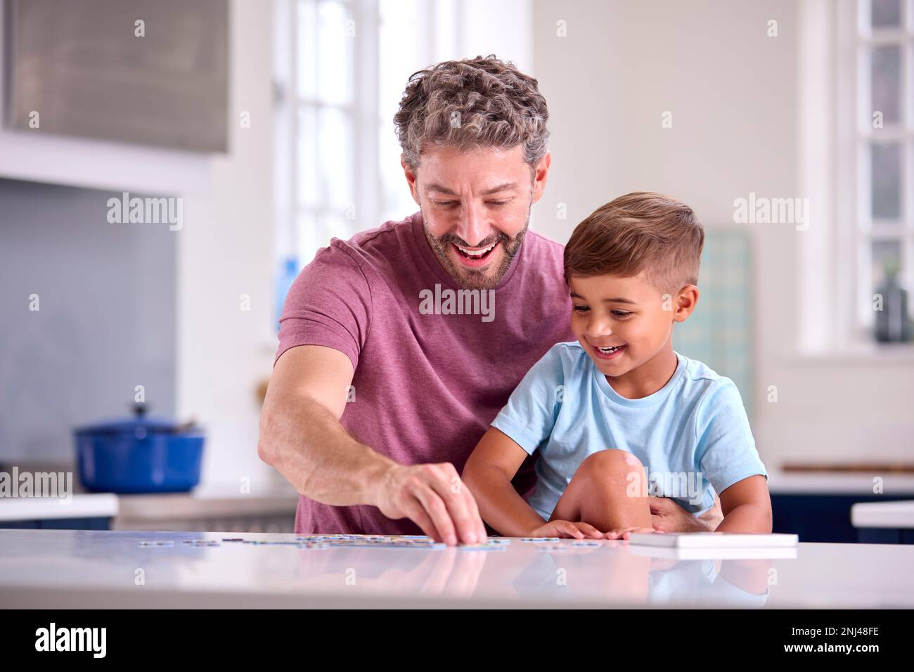 Reifer Vater Zu Hause In Der Küche, Mit Sohn, Der Zusammen Puzzle Spielt Stockfoto