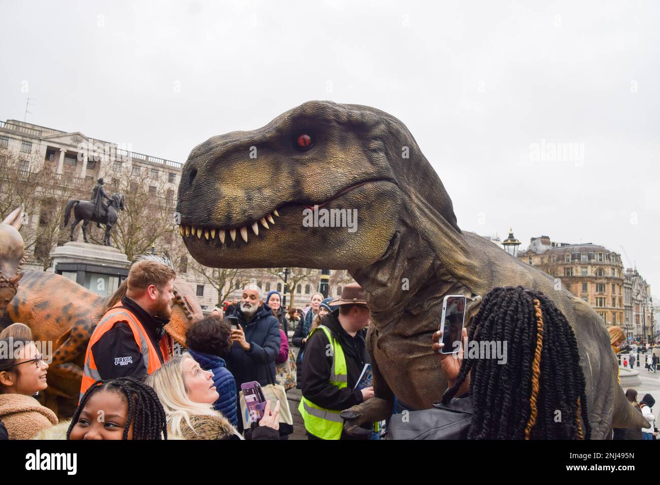 London, Großbritannien. 18. Februar 2023 Künstler in lebensechten Dinosaurierkostümen unterhalten die Massen am Trafalgar Square, während Jurassic Live seine West End Show im Adelphi Theatre startet. Stockfoto