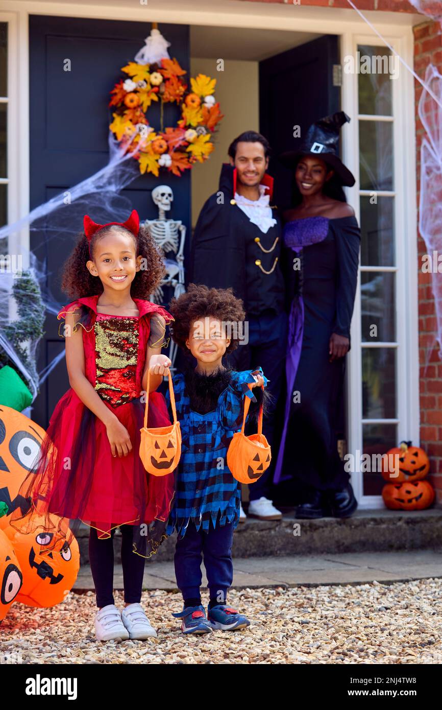 Porträt Der Familie, Die Sich Für Halloween Verkleidet, Vor Dem Haus Bereit Für Süßes Oder Saures Stockfoto