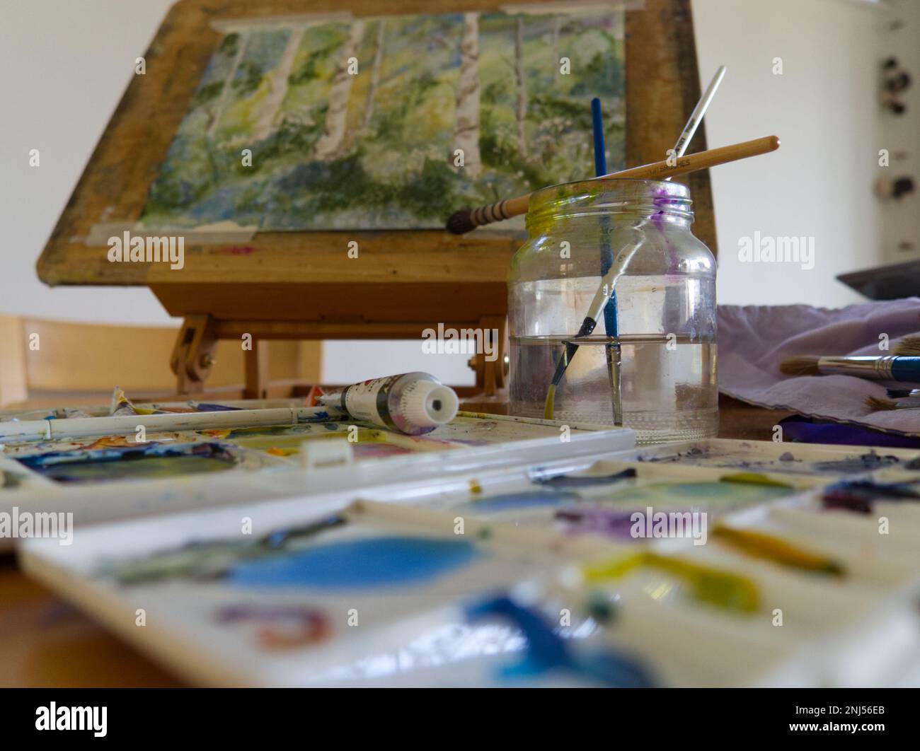 Künstler-Staffelei mit Aquarellfarben und Paintburschen Stockfoto