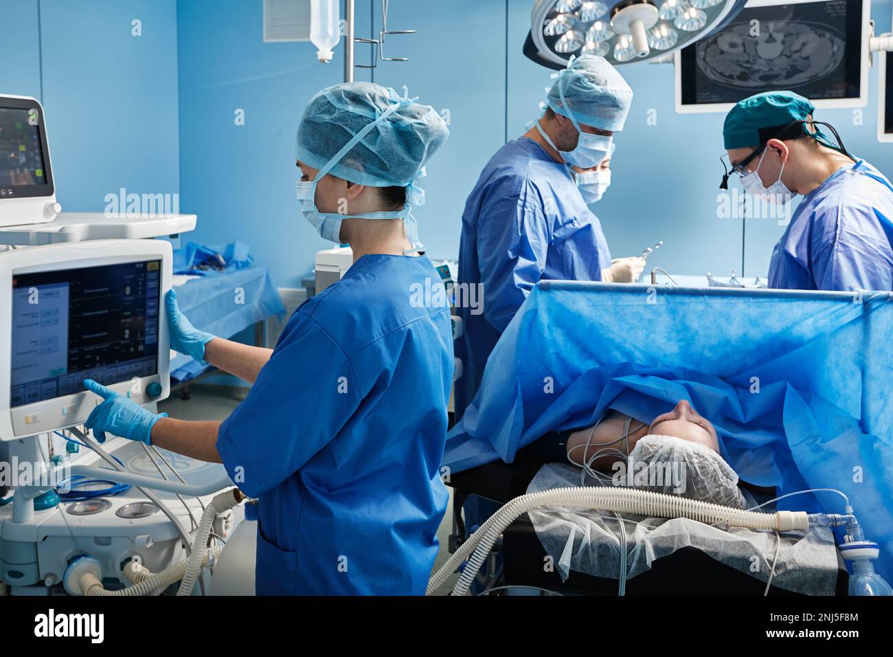 Krankenhausoperationssaal mit medizinischem Team, das während der Operation persönliche Schutzausrüstung trägt. Teamarbeit in der chirurgischen Abteilung Stockfoto Krankenhausoperationssaal mit medizinischem Team, das während der Operation persönliche Schutzausrüstung trägt. Teamarbeit in der chirurgischen Abteilung Stockfoto
