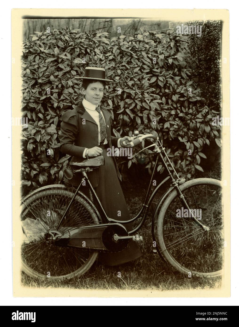 Originales viktorianisches Foto einer Frau mit ihrem Fahrrad in einem Garten, die einen Bootsfahrer trägt, alte Radtour, um 1897, Gegend von Worcester, GROSSBRITANNIEN Stockfoto
