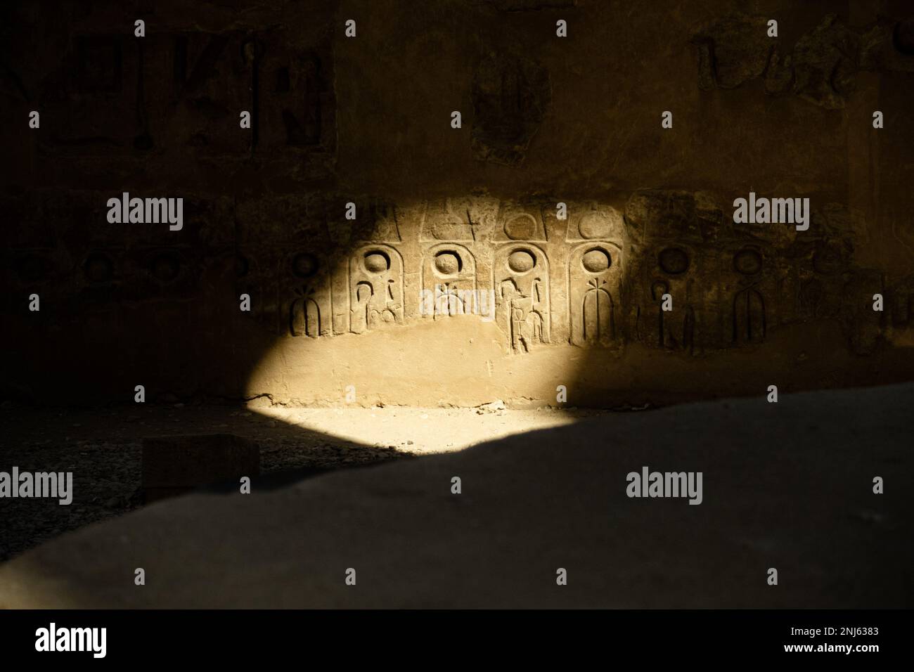 Hieroglyphen an einer Wand. Licht wird auf einen kleinen Bereich konzentriert. Erleichterung im luxor-Tempel Stockfoto
