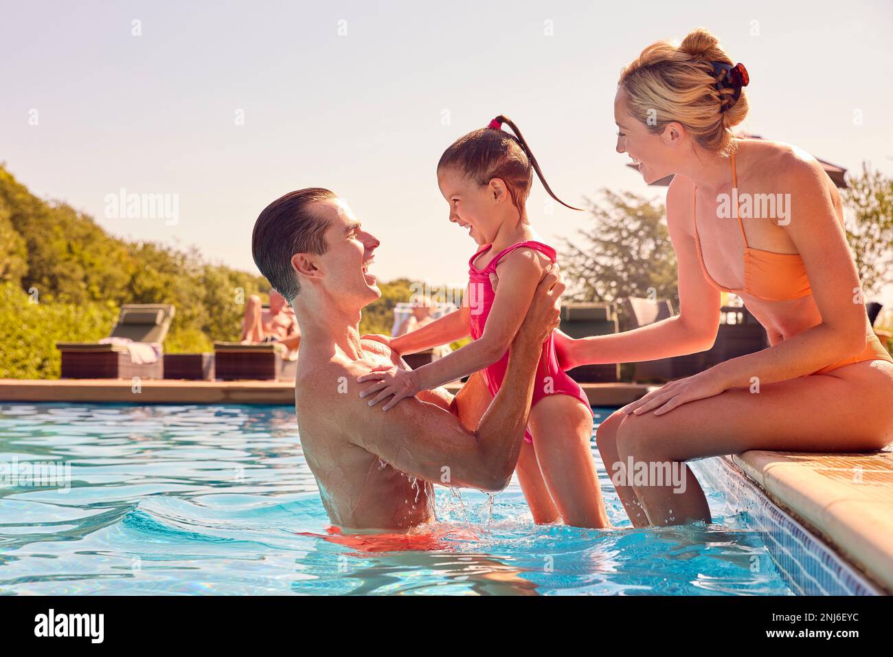Lächelnde Familie Im Sommerurlaub Im Swimmingpool Stockfoto