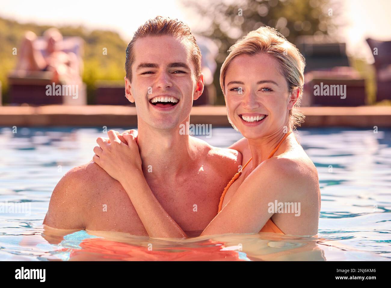 Porträt Eines Lächelnden Paares Im Sommerurlaub, Das Sich Im Swimmingpool Entspannen Kann Stockfoto