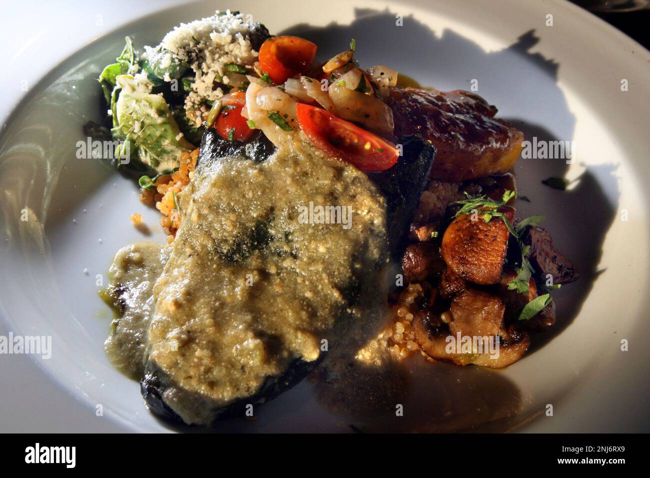 Plato vegetariano--chile relleno stuffed with grilled corn and queso oaxaca, quinoa pilaf, chard with raja crema, sauteed trumpet mushrooms and chipotle glazed butternut squash--at Marinitas, a new upscale Mexican restaurant in San Anselmo, Calif., on Friday, April 3, 2009. (Liz Hafalia/San Francisco Chronicle via AP) Stockfoto