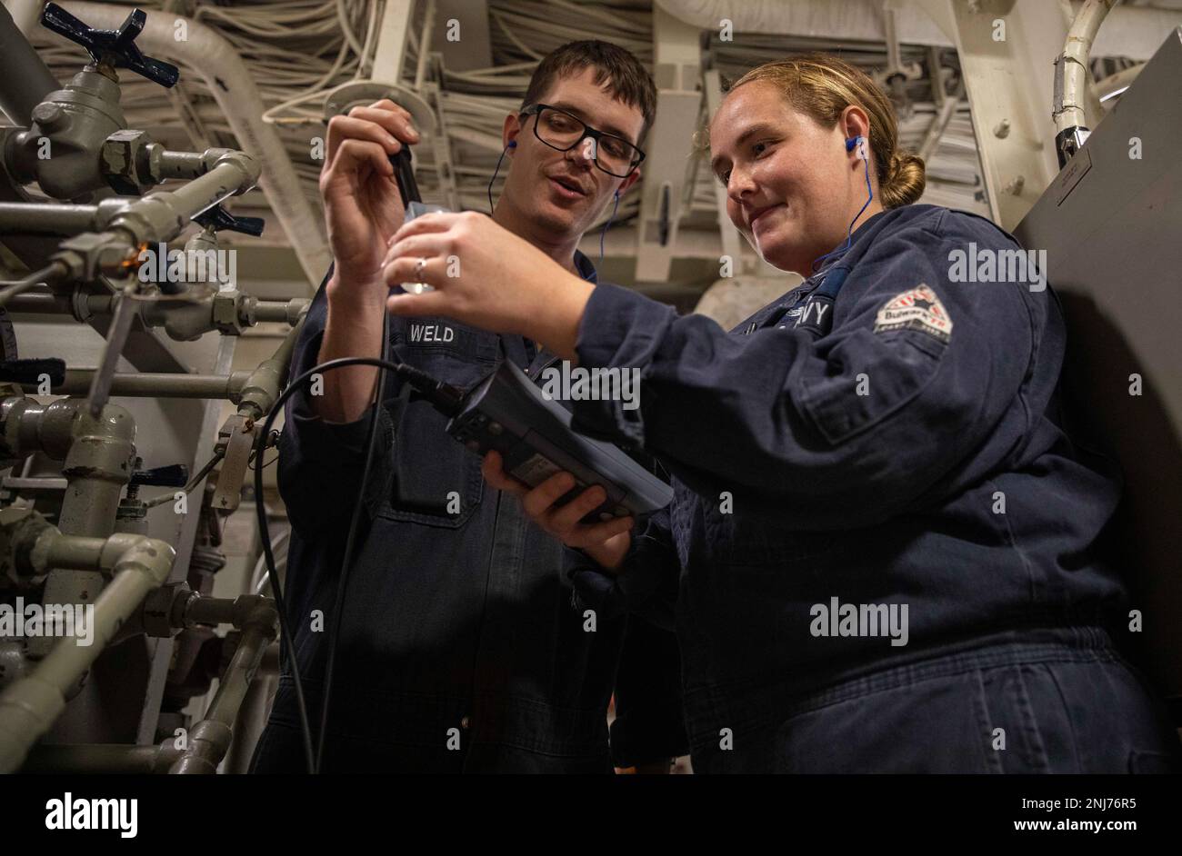 220805-N-YC581-2028 PAZIFIK (5. August 2022) – Machinist's Mate 2. Klasse Alec Weld, Left, and Gas Turbine System Technician (Electrical) 3. Klasse Veronica Pratt testet die Leitfähigkeit des Umkehrosmosesystems in einem Hauptmaschinenraum auf dem Amphibienschiff USS Makin Island (LHD 8), August 5. Regelmäßige Tests des Umkehrosmose-Systems stellen sicher, dass alle Matrosen und Marines auf Makin Island frisches Wasser zum Trinken, Hygiene und Kochen haben. Makin Island, das Flaggschiff der Amphibien-Staffel (CPR) SEVEN, sowie 13. Marine Expeditionary Unit (MEU), ist derzeit im Gespräch Stockfoto