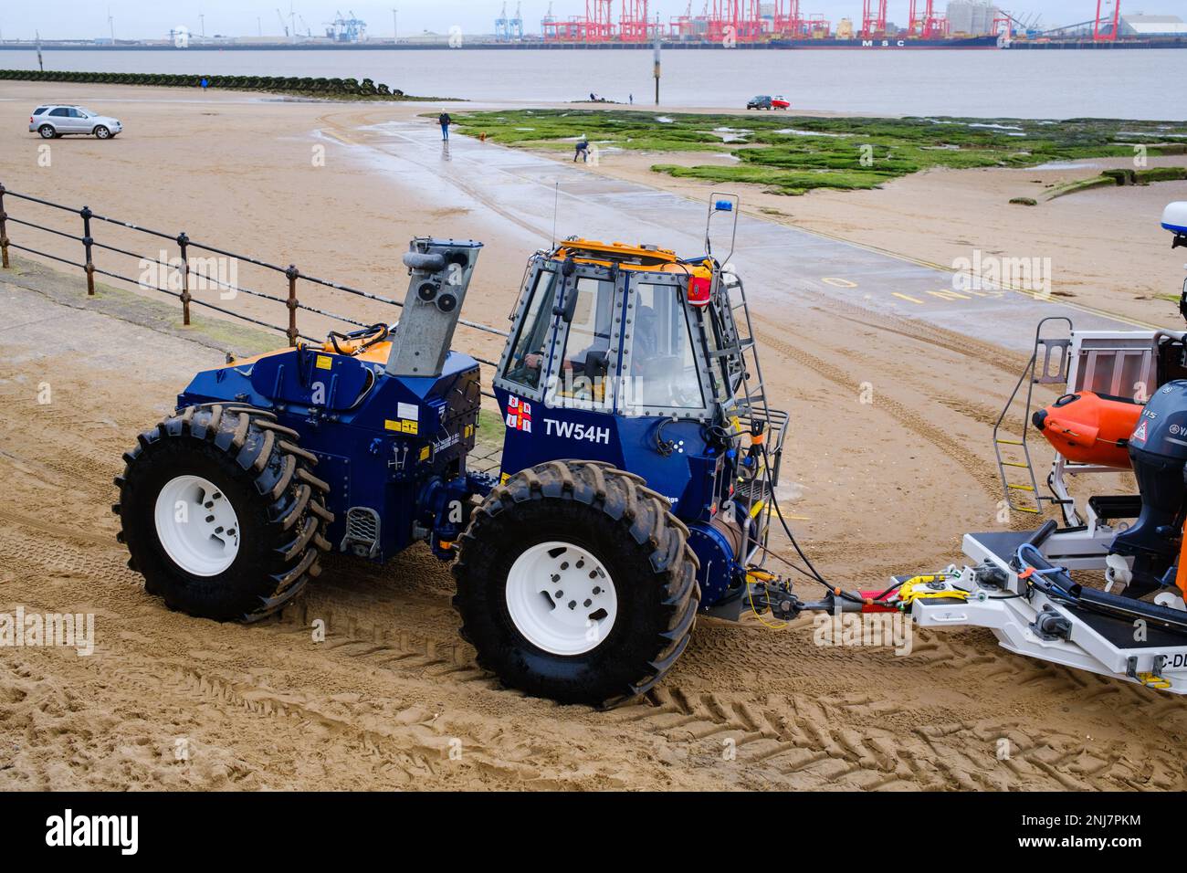 New Brighton Rettungsboot-Crew holt das Boot wieder am Strand ab, wobei der Traktor die Rippe auf einem Anhänger zieht, nachdem er eine Rettung auf dem Meer abgeschlossen hat Stockfoto