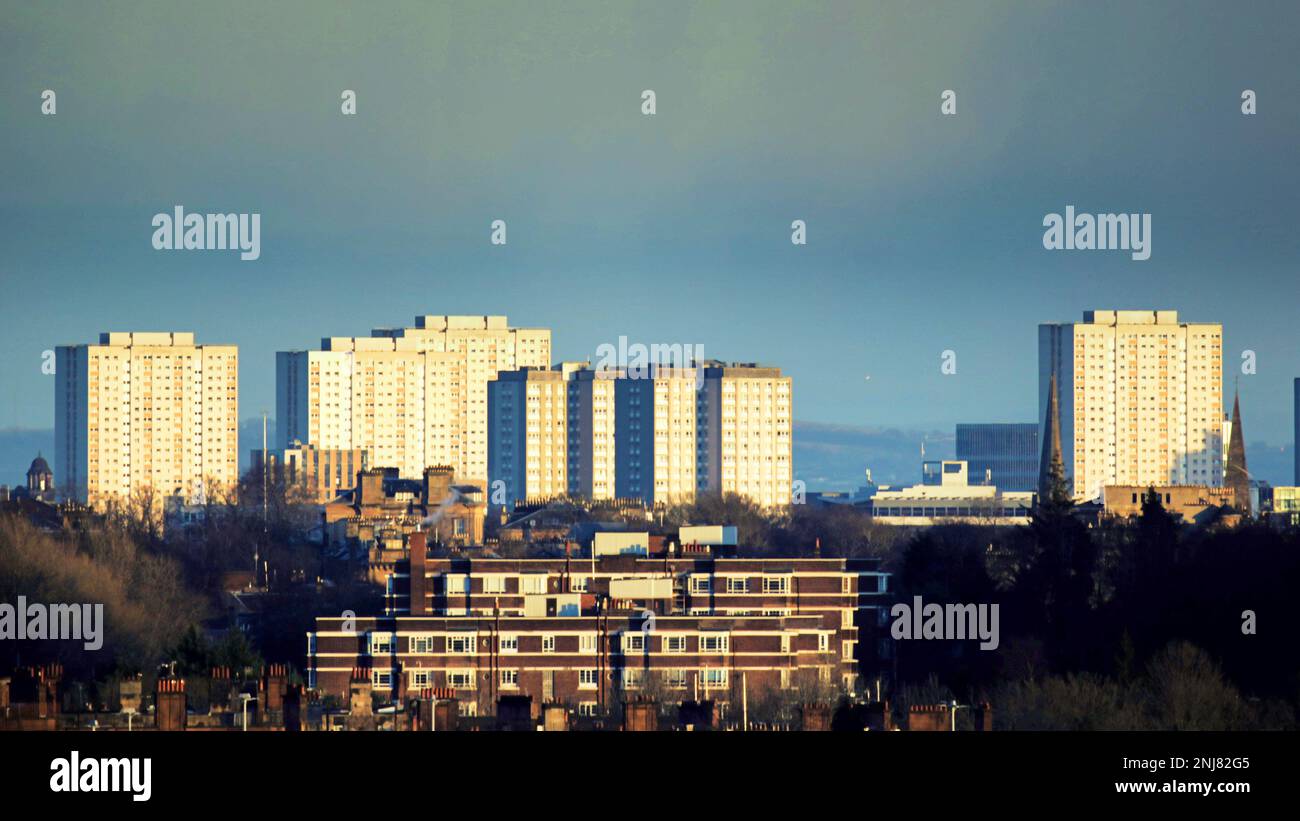 Glasgow, Schottland, Vereinigtes Königreich 22. Februar 2023. UK Weather: Nach Stürmen und schlechtem Wetter Sonne und Wolken über dem Westen der Stadt mit Schottlands Art déco Heritage Kelvin Court, Anniesland, erleuchtet von der untergehenden Sonne vor den 3 Meilen entfernten Hochhäusern im Stadtzentrum. Credit Gerard Ferry/Alamy Live News Stockfoto