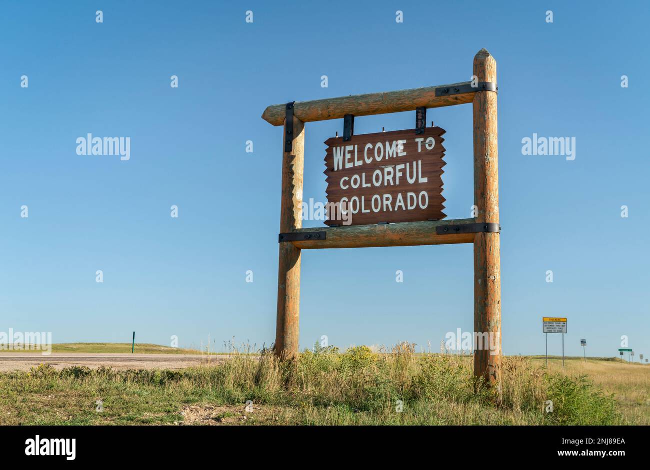 Willkommen auf dem farbenfrohen Holzschild am Straßenrand von Colorado an der Grenze zu Nebraska im Osten von Colorado Stockfoto