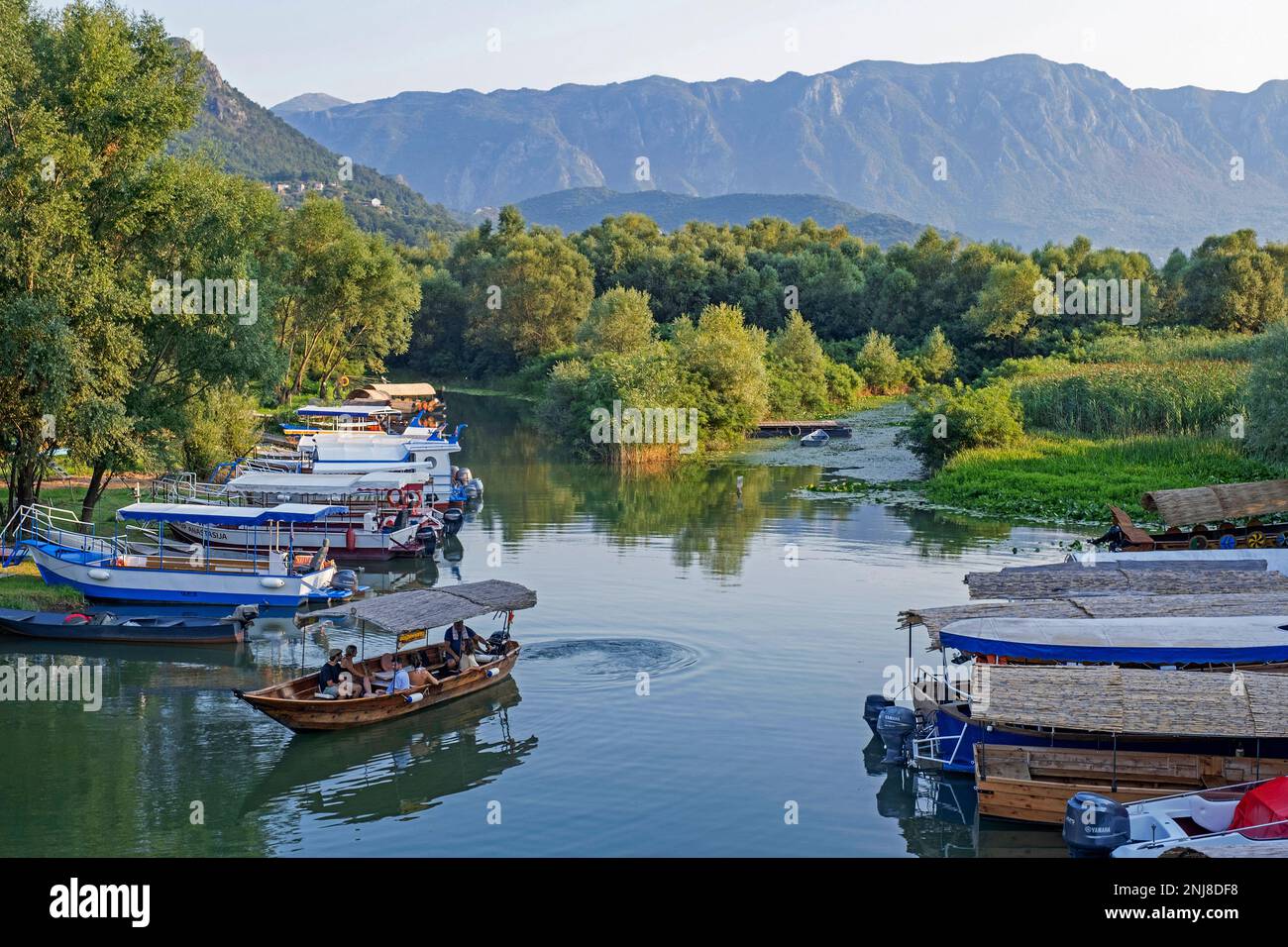 Touristenboote in Virpazar auf dem Crmnica Fluss, der in Skadar See, Skadarsko Jezero Nationalpark, Crmnica Region, Bar, Montenegro fließt Stockfoto