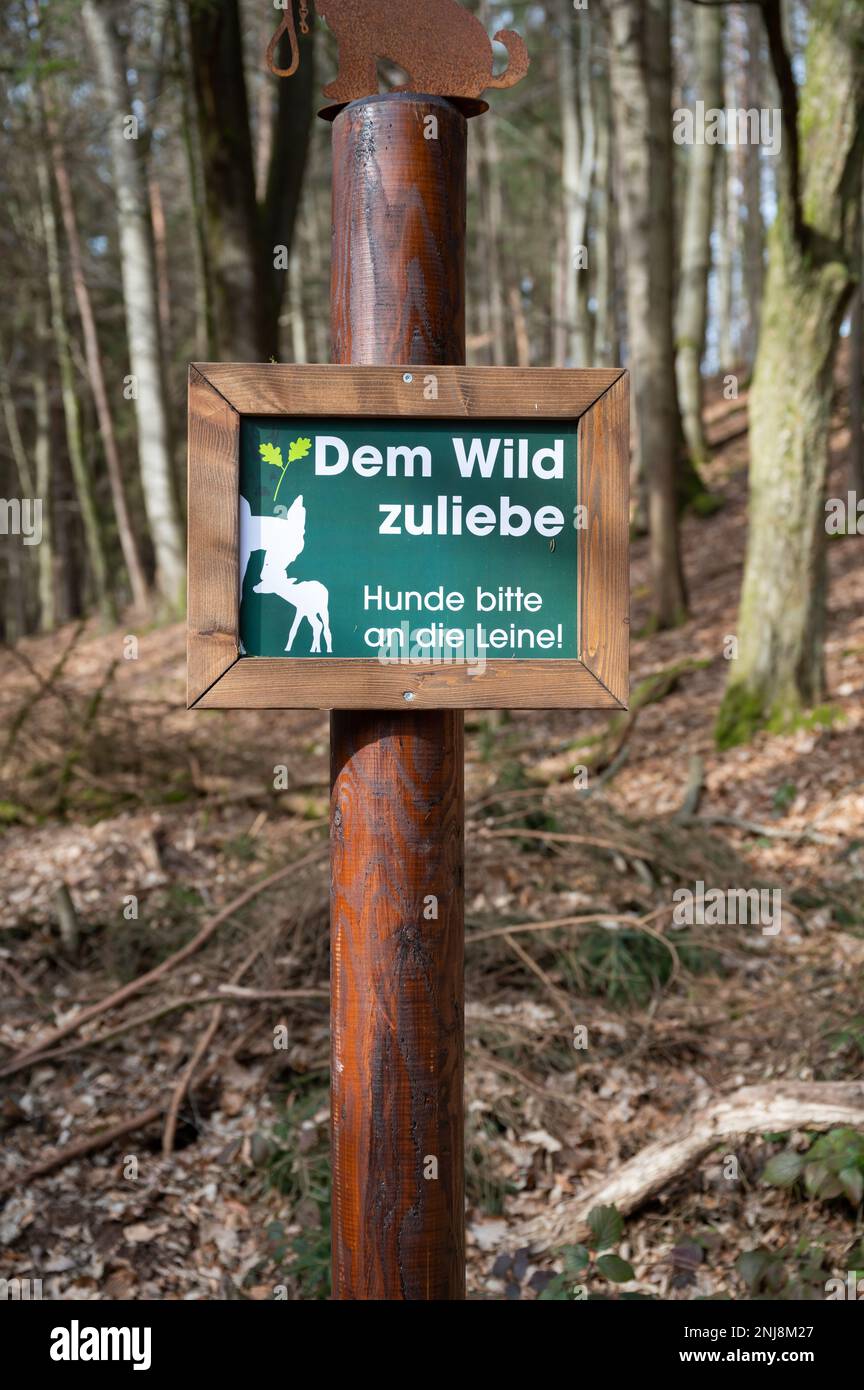 Deutsches Schild an einem Wildpark um der Wildnis willen, bitte halten Sie die Hunde an der Leine, vertikaler Schuss Stockfoto