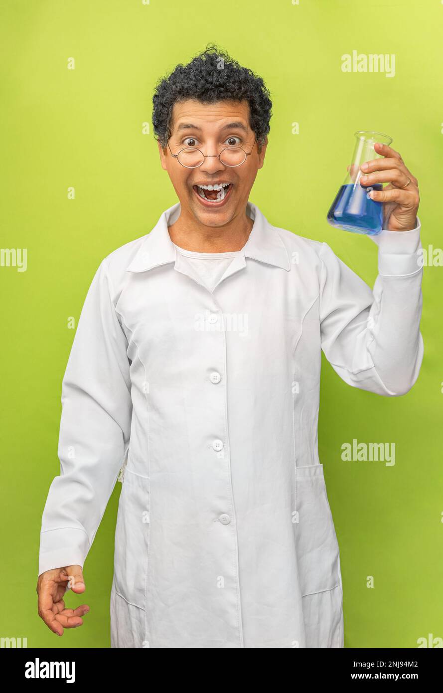 Portrait eines brasilianischen Genies Wissenschaftler glücklich mit seinem wissenschaftlichen Experiment auf grünem Hintergrund, Arzt mit weißem Kittel Stockfoto
