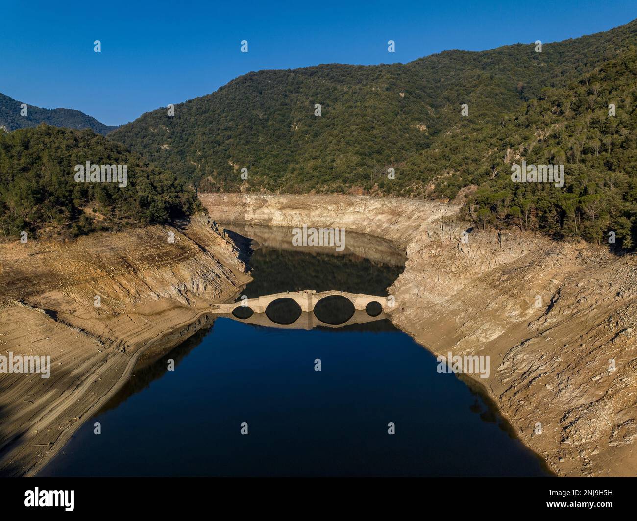 Luftaufnahme der mittelalterlichen Brücke von Querós, im Susqueda-Reservoir, sichtbar während einer Dürre mit 36 % Wasserstand (Katalonien, Spanien) Stockfoto
