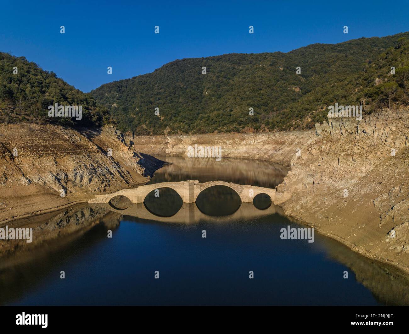 Luftaufnahme der mittelalterlichen Brücke von Querós, im Susqueda-Reservoir, sichtbar während einer Dürre mit 36 % Wasserstand (Katalonien, Spanien) Stockfoto