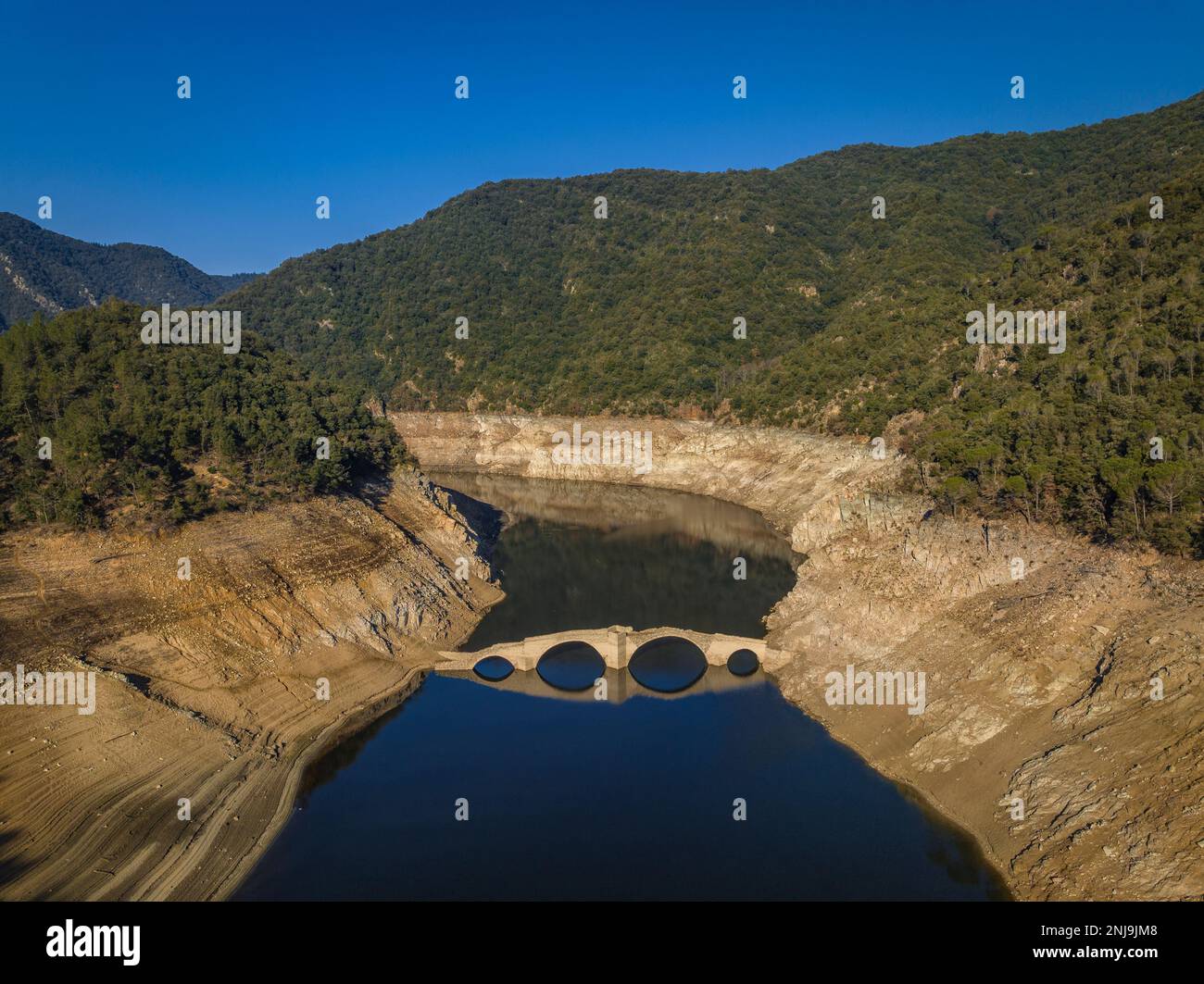 Luftaufnahme der mittelalterlichen Brücke von Querós, im Susqueda-Reservoir, sichtbar während einer Dürre mit 36 % Wasserstand (Katalonien, Spanien) Stockfoto