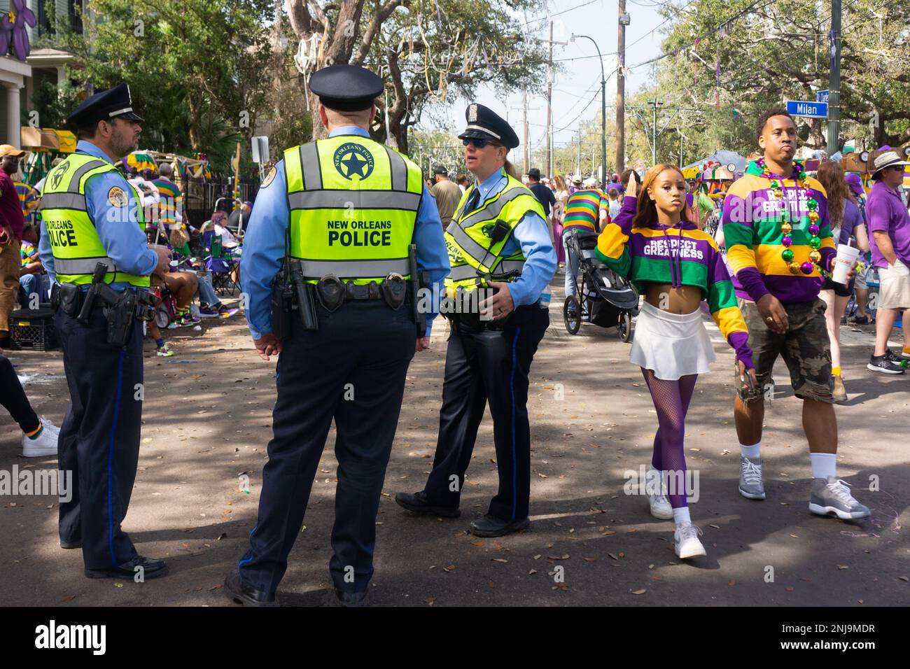 Ein schwarzes Paar überholt eine Gruppe weißer Polizisten am Mardi Gras Tag in New Orleans, 2023. Stockfoto