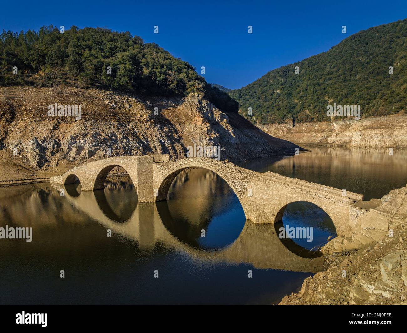 Luftaufnahme der mittelalterlichen Brücke von Querós, im Susqueda-Reservoir, sichtbar während einer Dürre mit 36 % Wasserstand (Katalonien, Spanien) Stockfoto