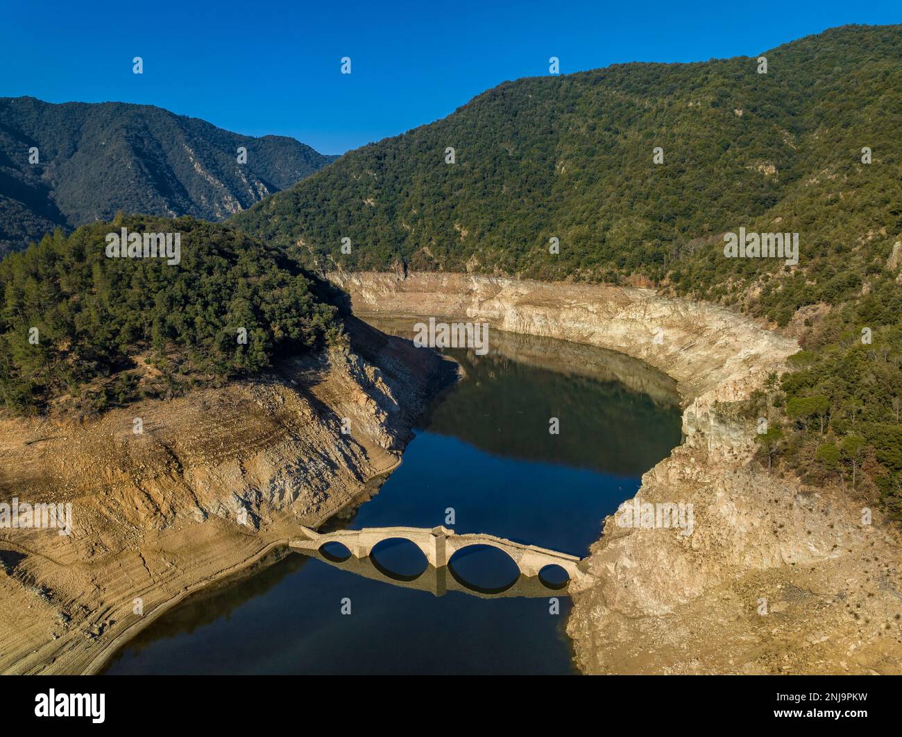 Luftaufnahme der mittelalterlichen Brücke von Querós, im Susqueda-Reservoir, sichtbar während einer Dürre mit 36 % Wasserstand (Katalonien, Spanien) Stockfoto