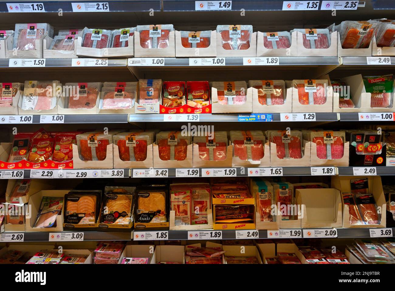 Regale im Supermarkt mit Päckchen haltbar gemachtem Räucherfleisch, Salami, Chorizo, Speck, Stockfoto
