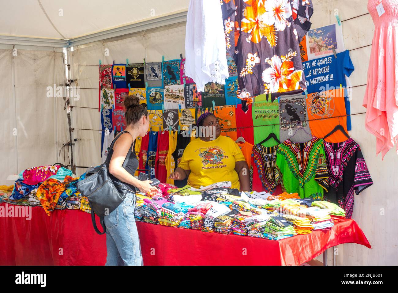 Junge Frau, die Souvenir-T-Shirts am Kai, Fort-de-France, Martinique, kleine Antillen, Karibik einkauft Stockfoto