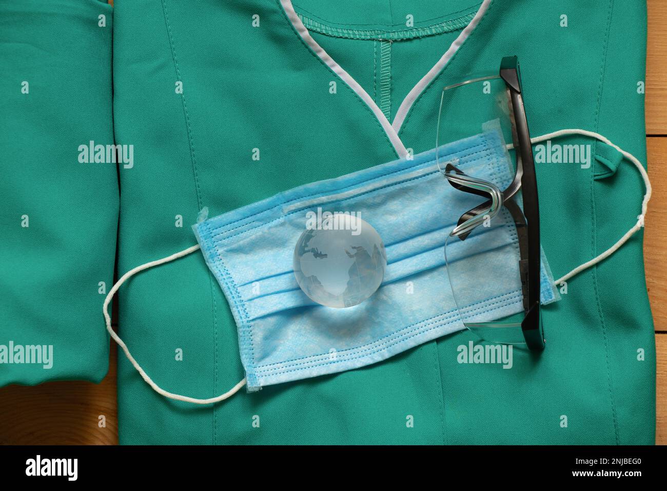 Set aus medizinischer Uniform und Glaskugel auf isoliertem Hintergrund Stockfoto