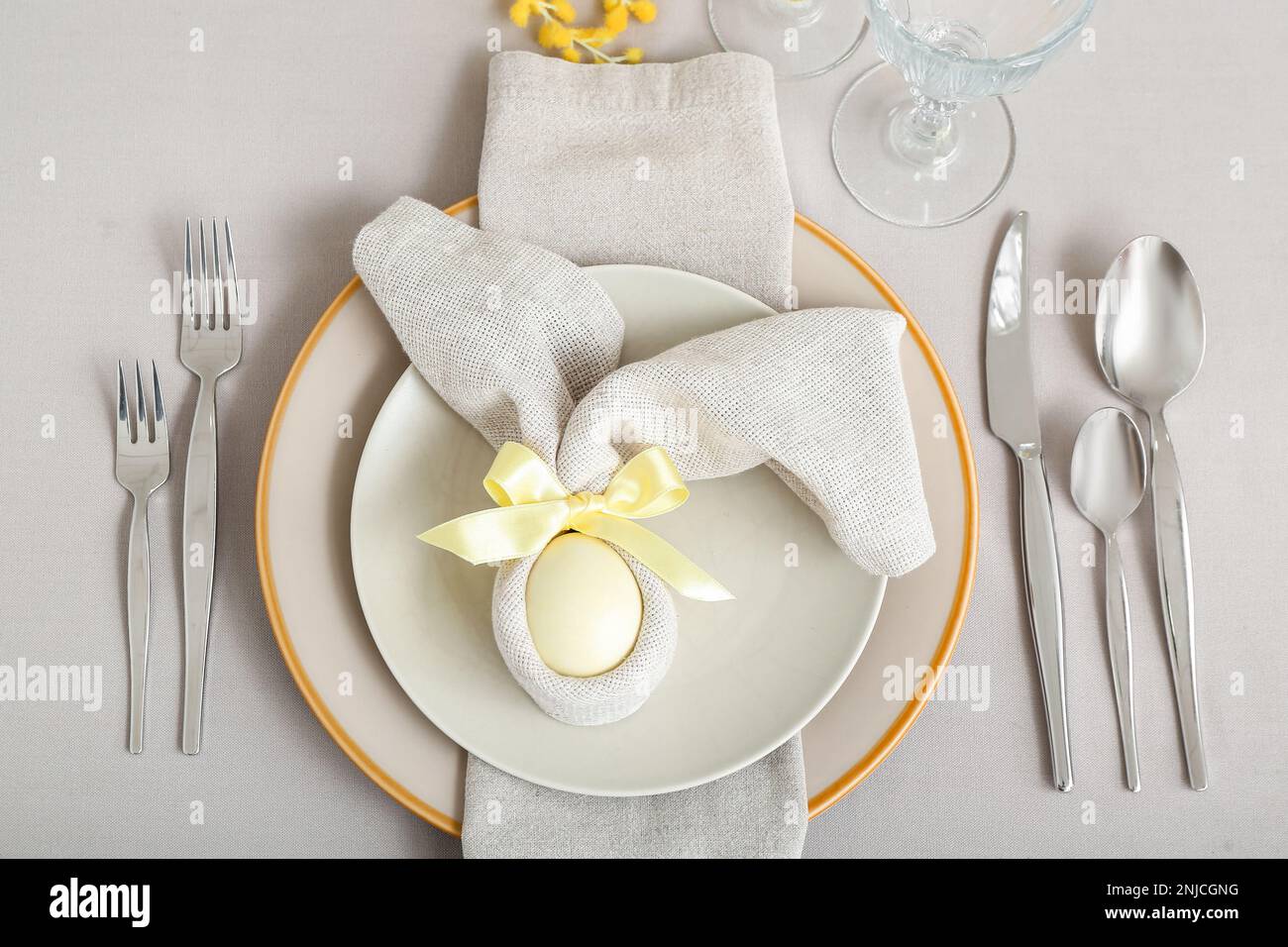 Tischdecken mit bemaltem Ei in Serviette werden zu Osterfeiern serviert Stockfoto