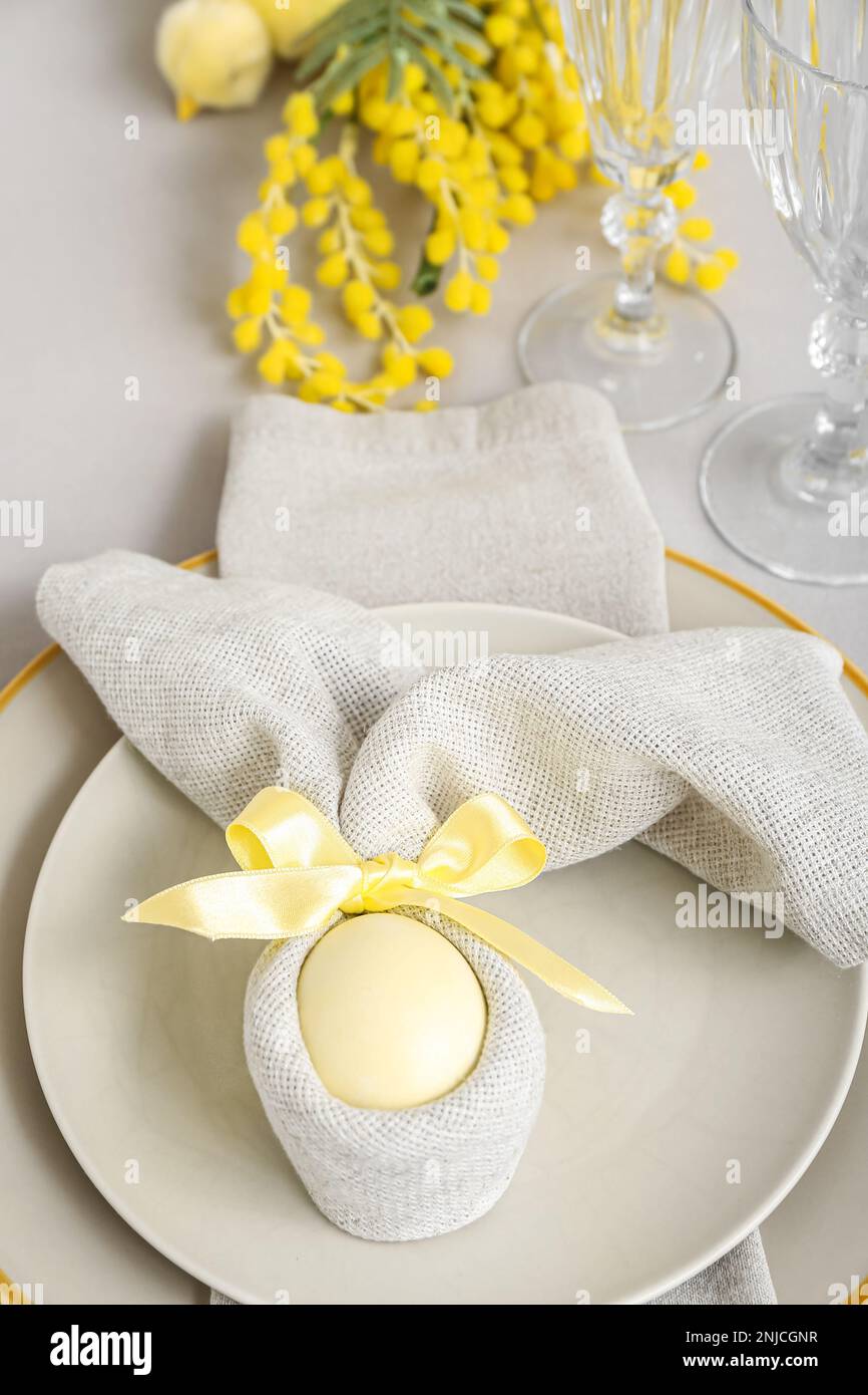 Tischdecken mit bemaltem Ei in Serviette werden zu Osterfeiern serviert Stockfoto