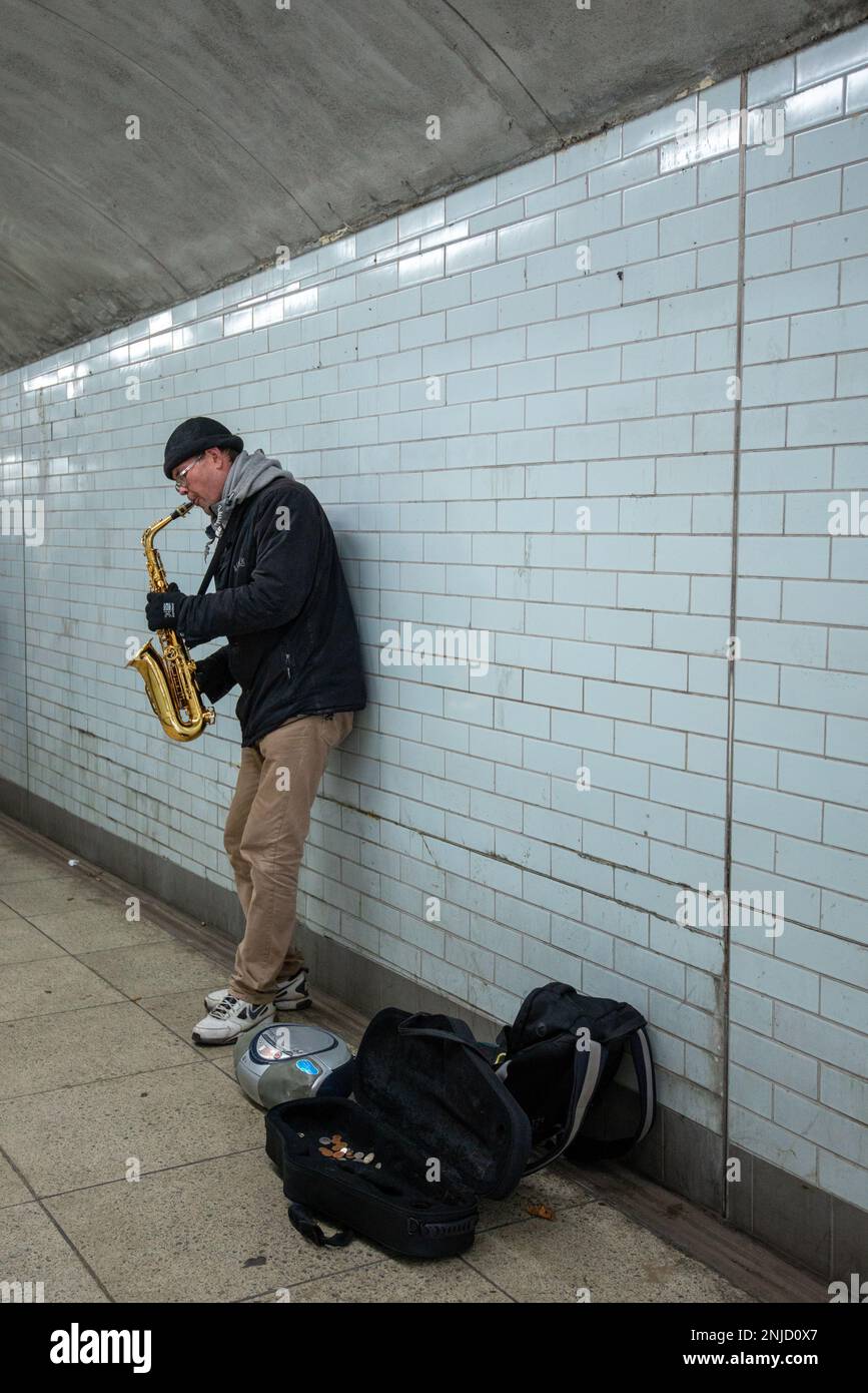 Busker spielt Saxophon in der U-Bahn-Station in London Stockfoto