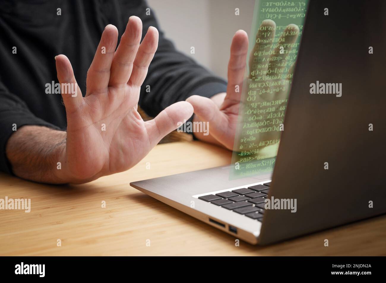 Die Hände werden vom Laptop aus mit Stoppgesten zurückgeworfen, während unbekannter Code auf dem Bildschirm erscheint, das Konzept von Cyberkriminalität wie Hackerangriffen, Ransomware und Stockfoto