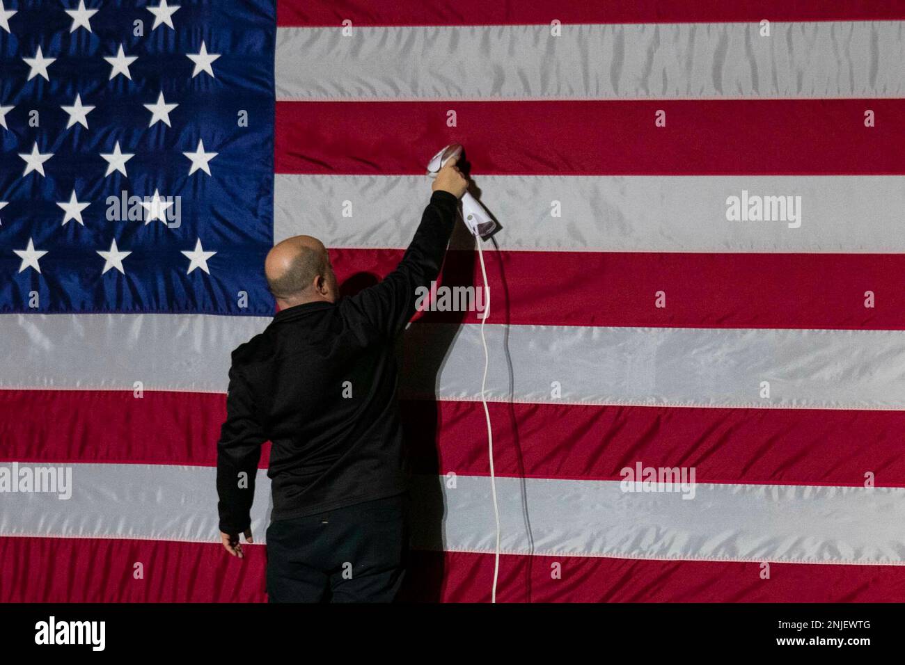 Bowie, Maryland, USA. 22. Februar 2023. Am Mittwoch, den 22. Februar, fährt eine Person vor einer Veranstaltung mit US-Vizepräsident Kamala Harris und Marcia Fudge, Sekretärin für Wohnungsbau und Stadtentwicklung (HUD) an der Bowie State University in Bowie, Maryland, USA, mit einer amerikanischen Flagge. 2023. Guthaben: Sarah Silbiger/Pool über CNP/dpa/Alamy Live News Stockfoto