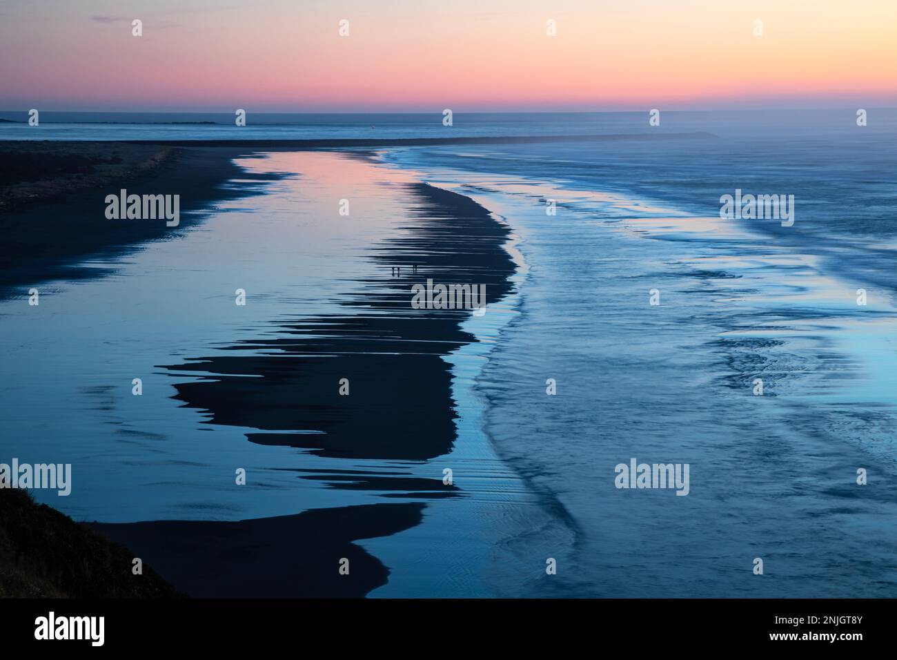 WA23037-00...WASHINGTON - bei Sonnenuntergang am Zusammenfluss des Columbia River und des Pazifischen Ozeans im Cape Disappointment State Park. Stockfoto