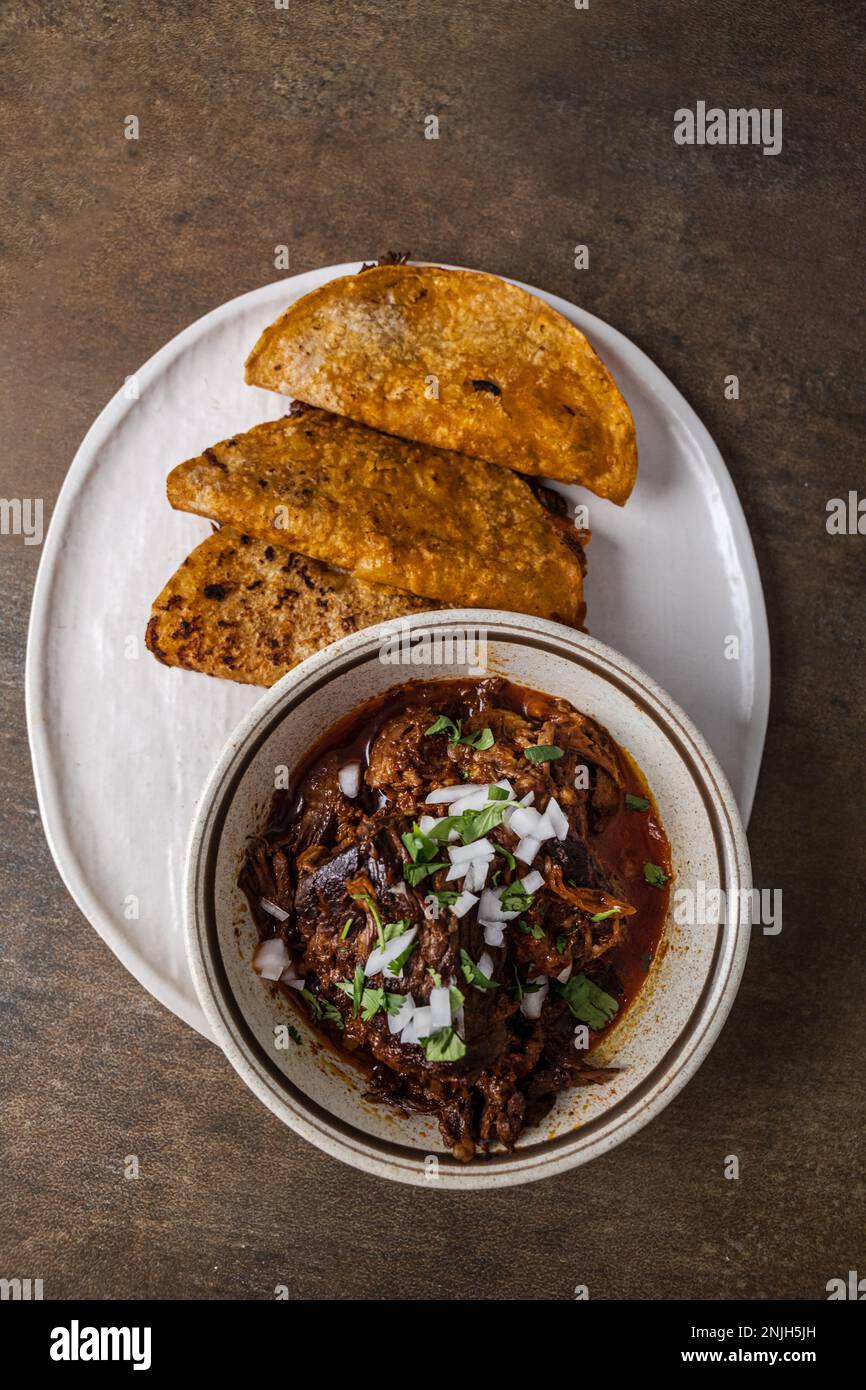 Ein Teller mexikanischer Beef Birria Tacos mit Rinderhack, Zwiebeln ...