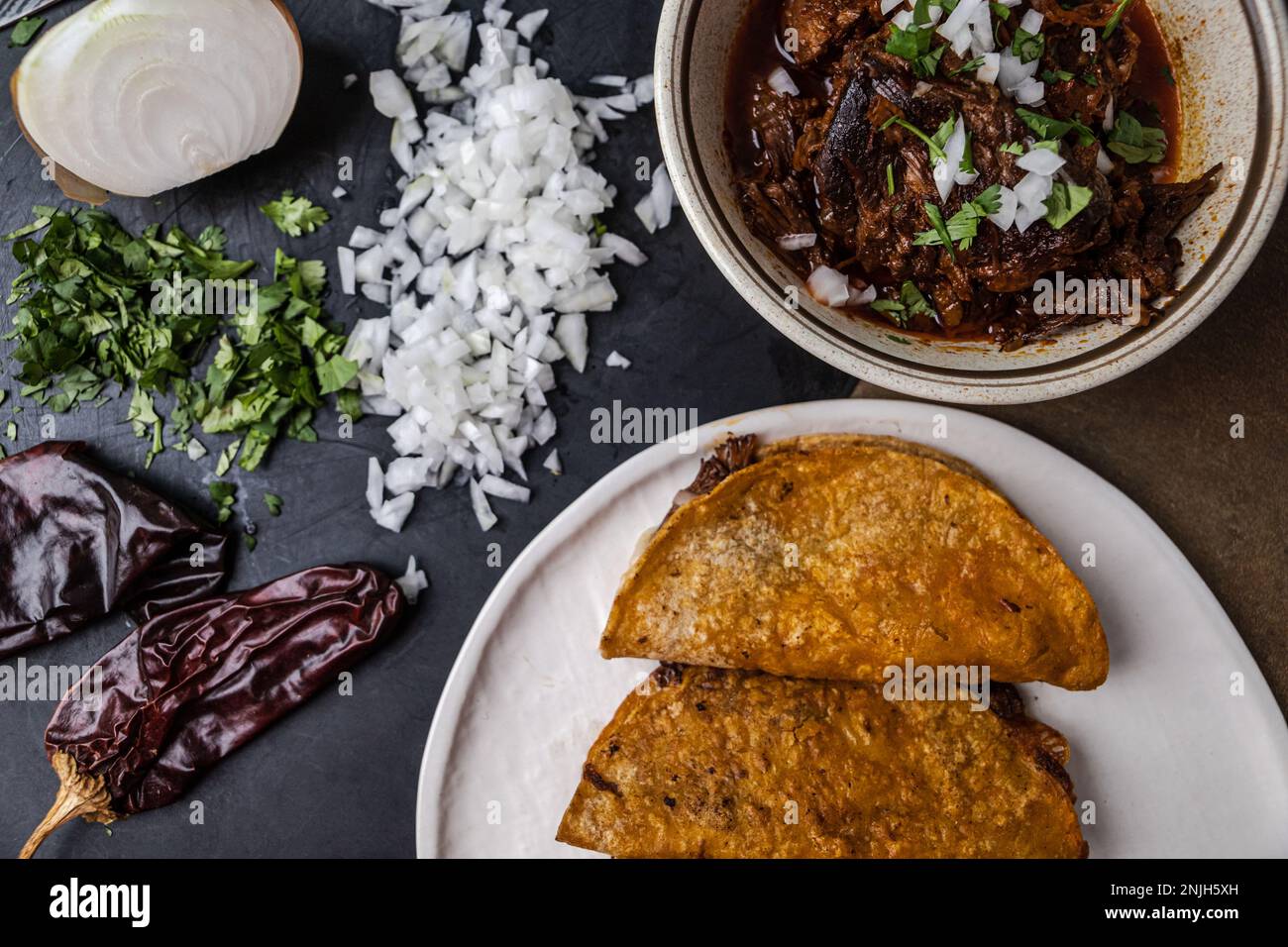 Ein Teller mexikanischer Beef Birria Tacos mit Rinderhack, Zwiebeln ...