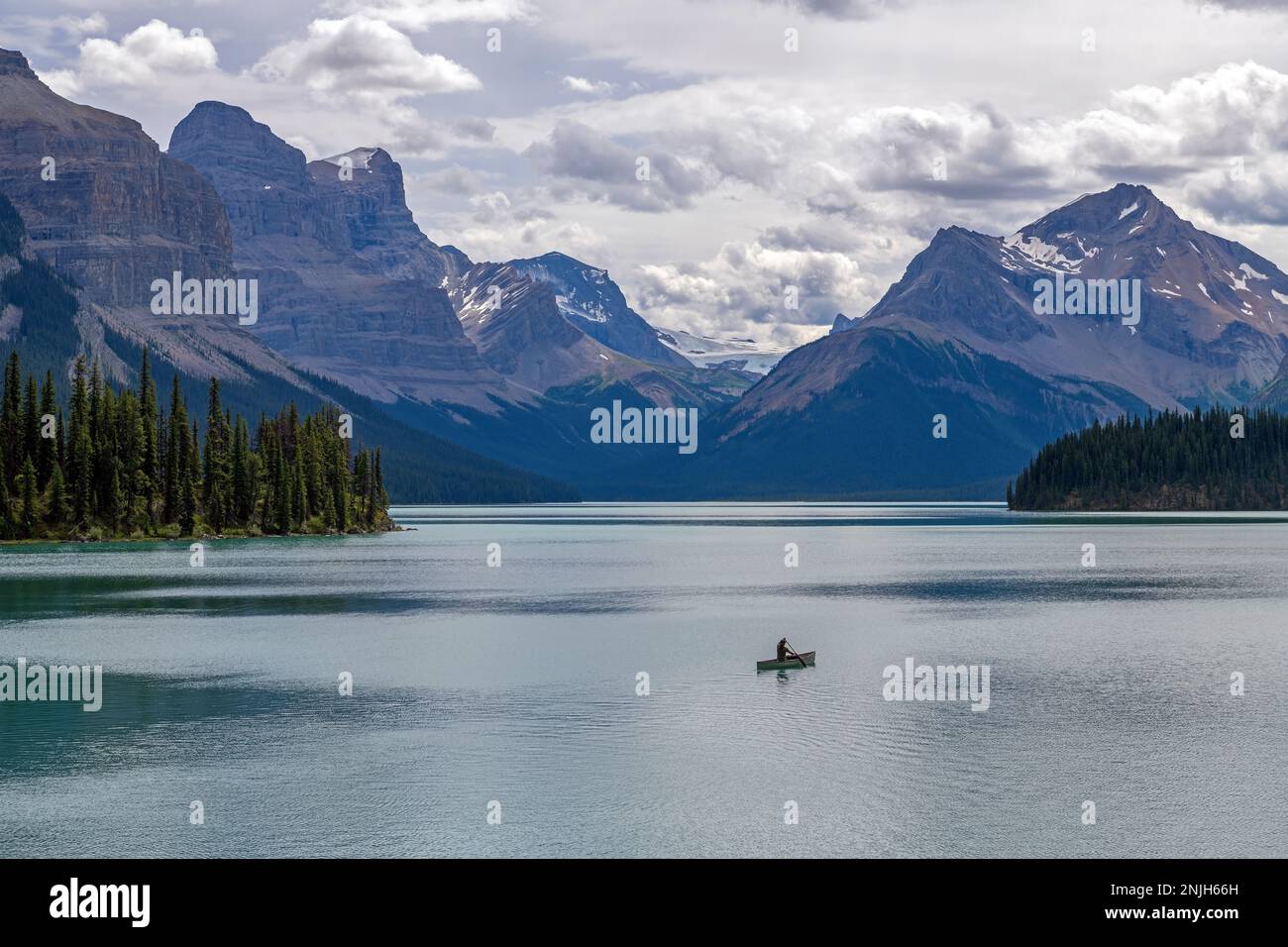 Mann im Kanu auf dem Maligne Lake in den kanadischen felsigen Bergen, Jasper-Nationalpark, Alberta, Kanada. Stockfoto