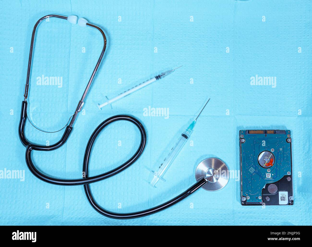 Medizinisches Tablett mit Stethoskop, Nadeln und Diskettenlaufwerk symbolisiert medizinische Technologie und Daten Stockfoto