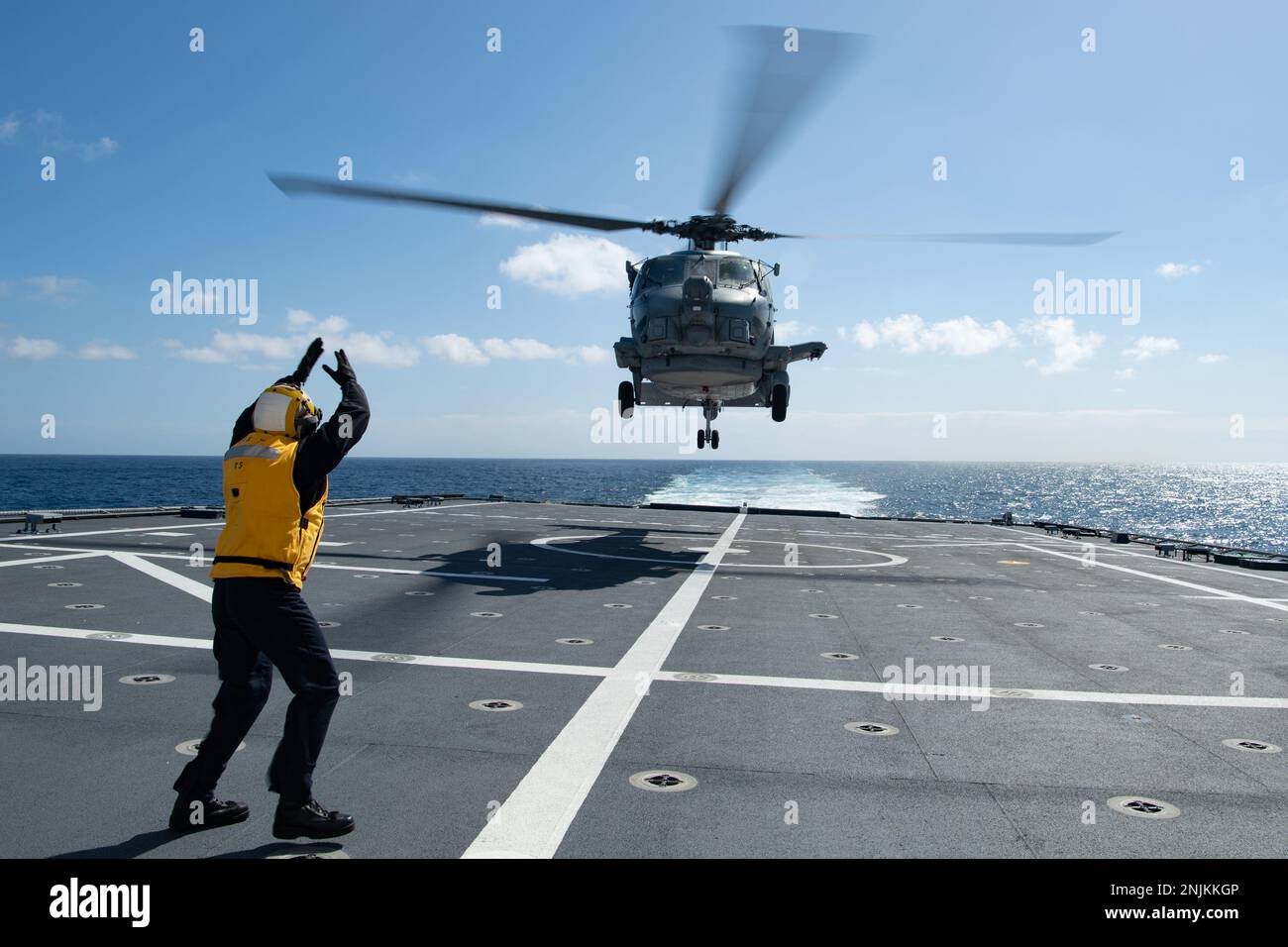 230218-N-MK318-1417 OSTPAZIFIK (18. Feb. 2023) Sonar Technician (Surface) 2. Klasse Quinn Vaticano, ein blauer Matrose an Bord des Kampfschiffs USS Mobile (LCS 26) der Independence-Variante signalisiert einem MH-60R Hubschrauber, der am Helicopter Maritime Strike Squadron 49 (HSM 49) befestigt ist, vom Cockdeck des Schiffes abzuheben, Februar 18. Küstenschiffe sind schnelle, optimal bemannte, auf die Mission zugeschnittene Surface Combatants, die in küstennahen und offenen Meeresumgebungen operieren und gegen die Bedrohungen der Küste des 21. Jahrhunderts gewinnen. Mobile führt derzeit Routinevorgänge in den USA durch Stockfoto