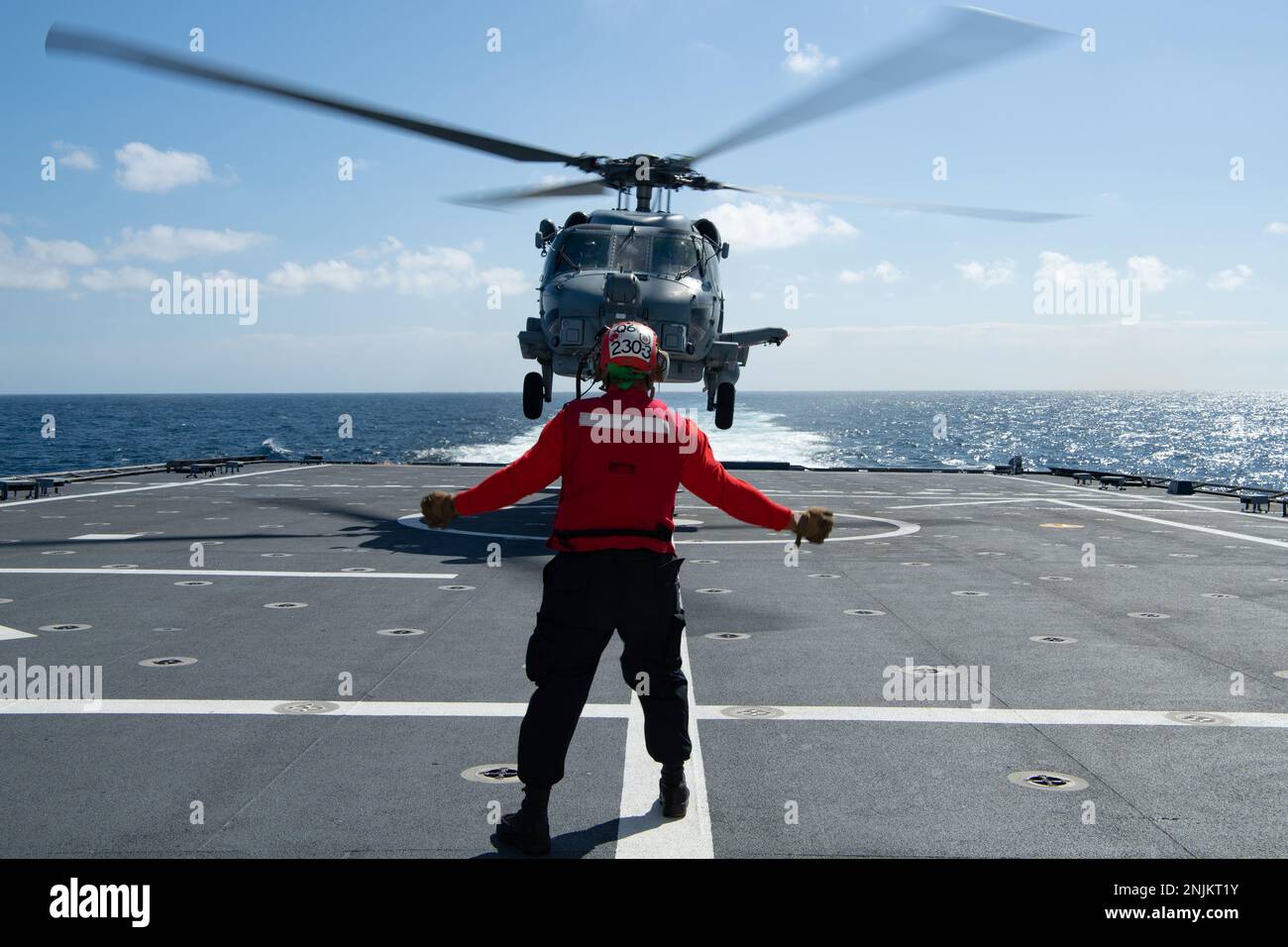 230218-N-MK318-1453 OSTPAZIFIK (18. Feb. 2023) Aviation Ordnanceman 2. Class Alexander Gomes, zugewiesen zum Helicopter Maritime Strike Squadron 49 (HSM 49), signalisiert einem MH-60R Helikopter, vom Cockpit an Bord des Kampfschiffs USS Mobile (LSC 26) der Independence-Variante vom Cockpit abzuheben. Feb. 18. Küstenschiffe sind schnelle, optimal bemannte, auf die Mission zugeschnittene Surface Combatants, die in küstennahen und offenen Meeresumgebungen operieren und gegen die Bedrohungen der Küste des 21. Jahrhunderts gewinnen. Mobile führt derzeit Routinevorgänge in der US-3.-Flotte durch. (USA Navy Foto von Ma Stockfoto